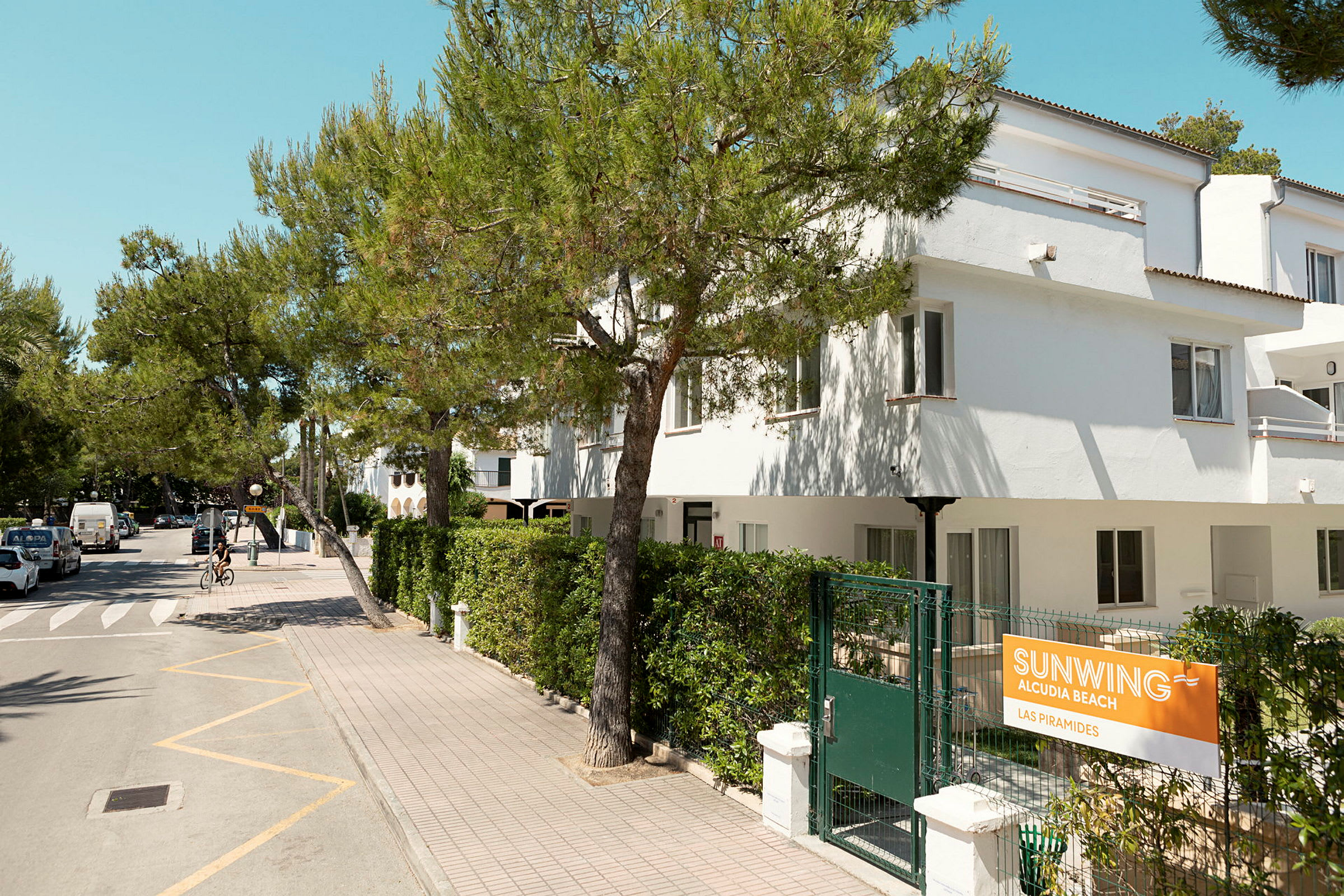 Hotelli Sunwing Alcudia Beach Las Piramides, jossa on vehreyttä ja puuterassi. (Tekoälyn luoma teksti)