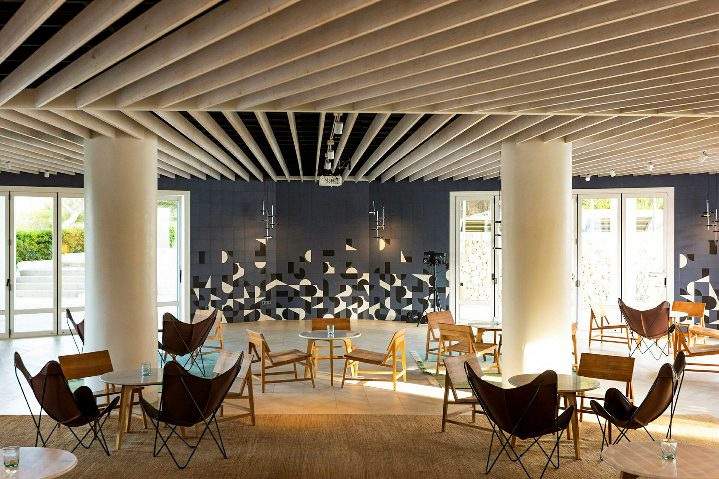 Moderni lounge-tila istuimilla ja geometrisilla koristeilla seinällä. (Tekoälyn luoma teksti)