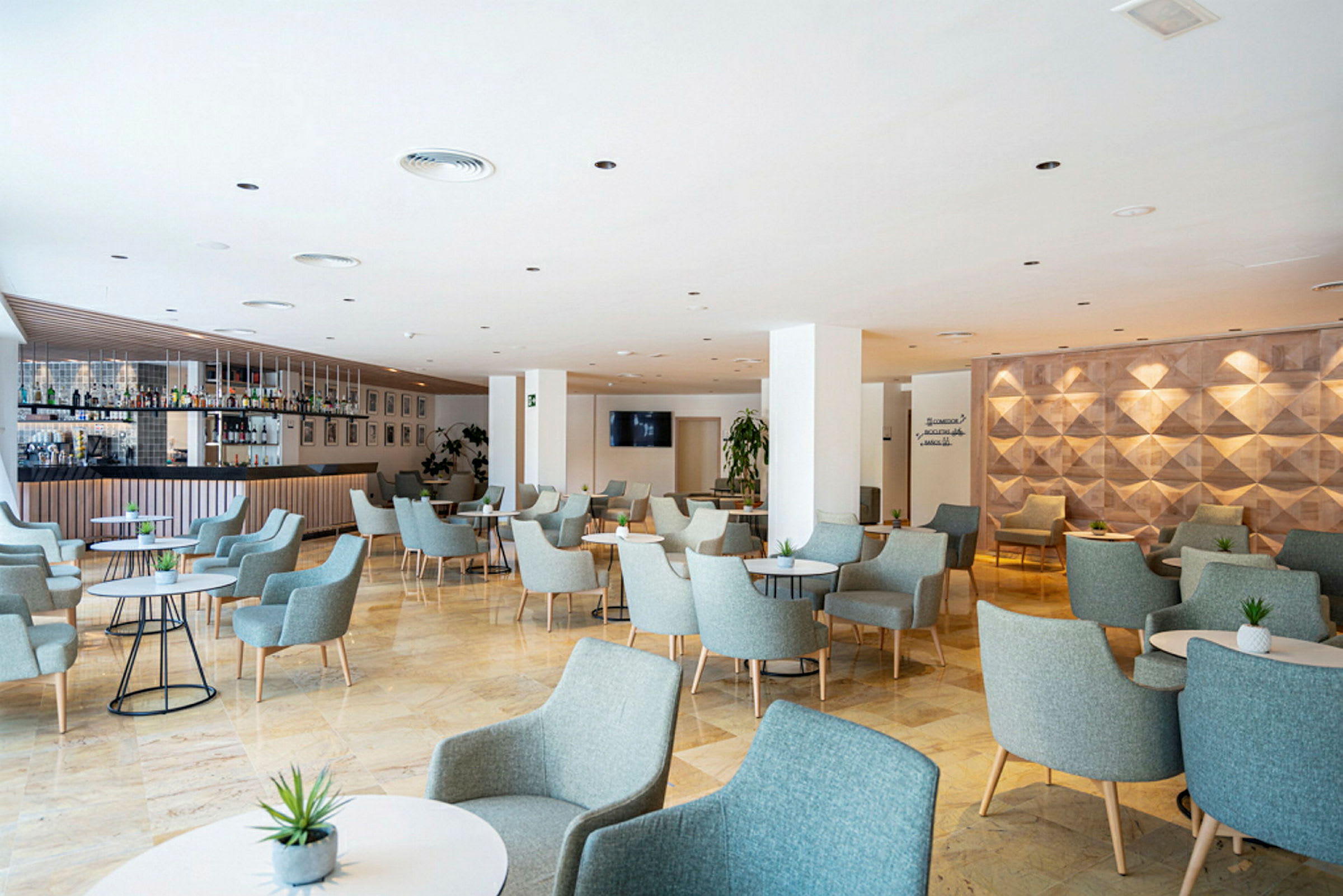 Moderni lounge-alue, jossa on pöytiä ja tuoleja. (Tekoälyn luoma teksti)