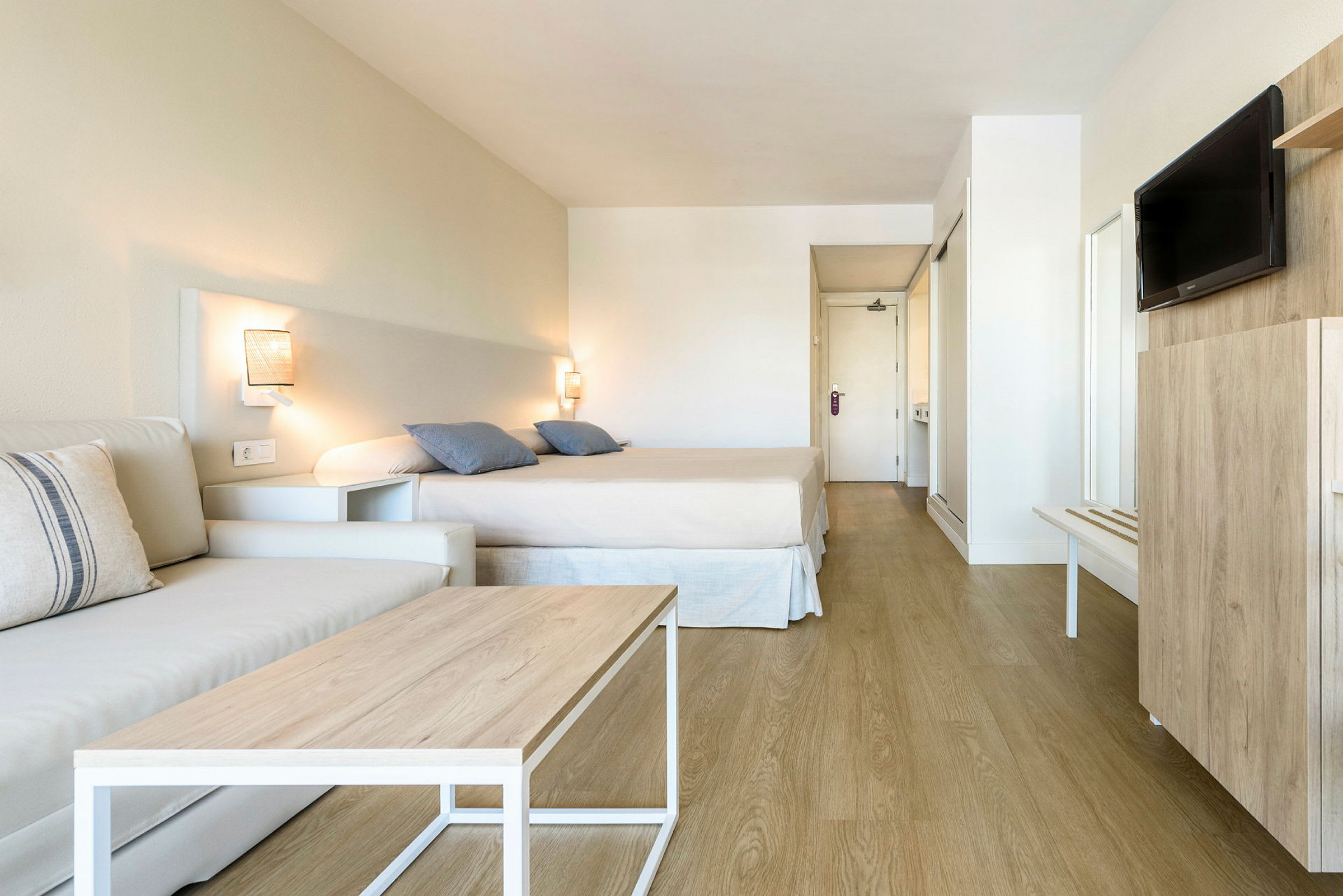 Hotellihuone, jossa sänky, sohva ja televisio. (Tekoälyn luoma teksti)