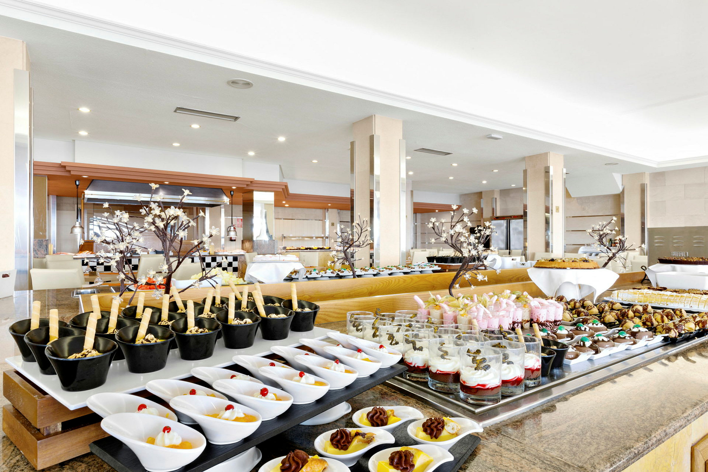 Buffet, jossa erilaisia jälkiruokia ja leivonnaisia. (Tekoälyn luoma teksti)