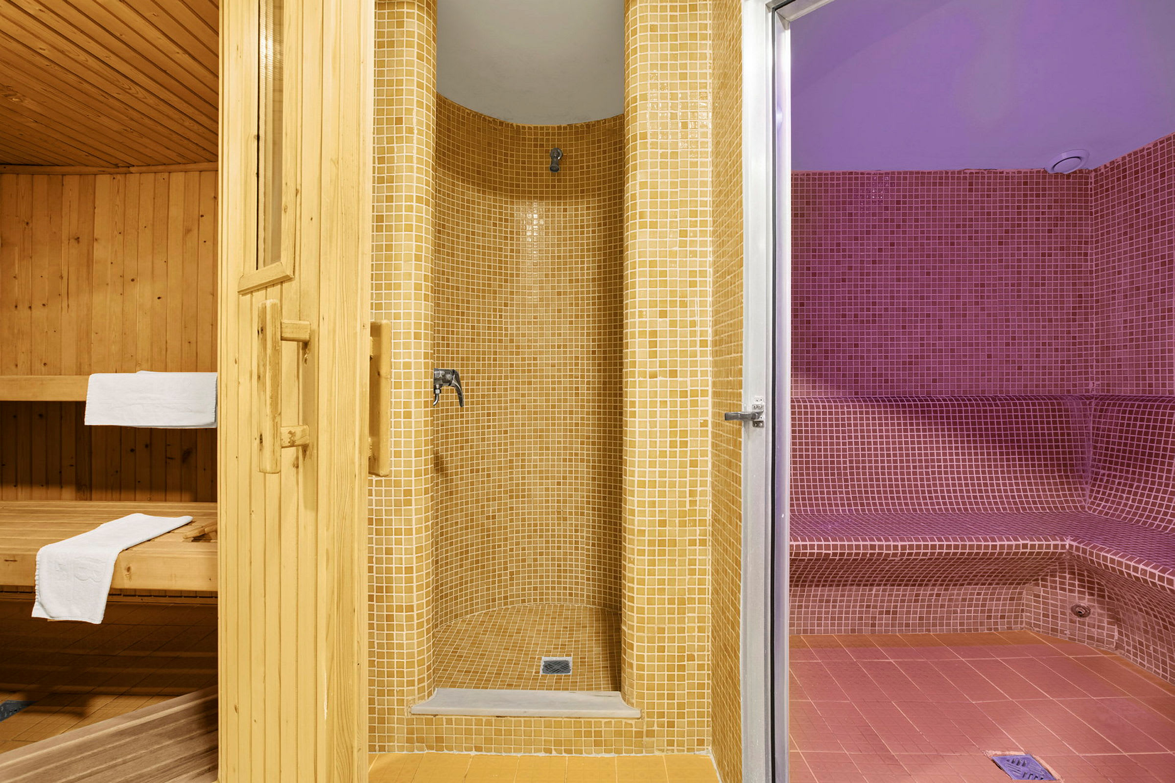 Kolme aluetta: puusauna, beige mosaiikkisuihku ja punainen mosaiikkihöyrysauna. (Tekoälyn luoma teksti)
