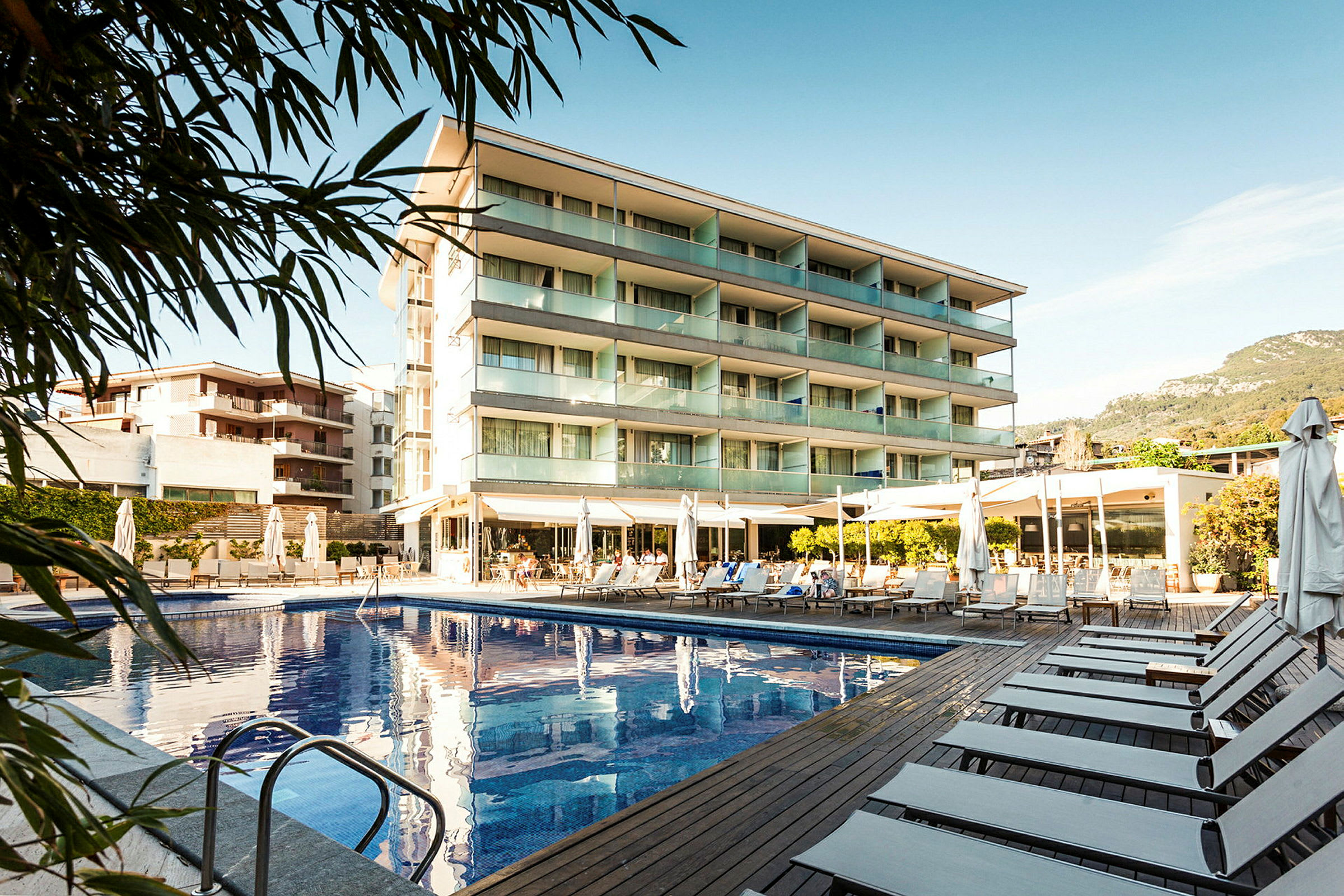 Kuva hotellista, jossa on ulkouima-allas ja aurinkotuoleja. (Tekoälyn luoma teksti)