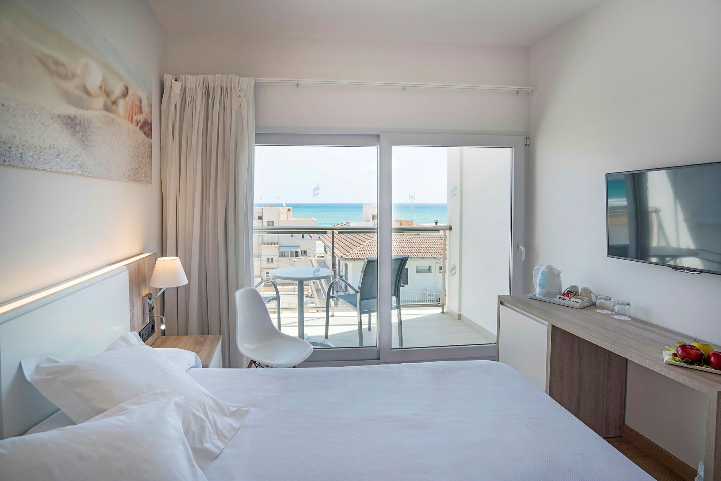 Hotellihuone, jossa sänky, kirjoituspöytä ja parveke merinäköalalla. (Tekoälyn luoma teksti)