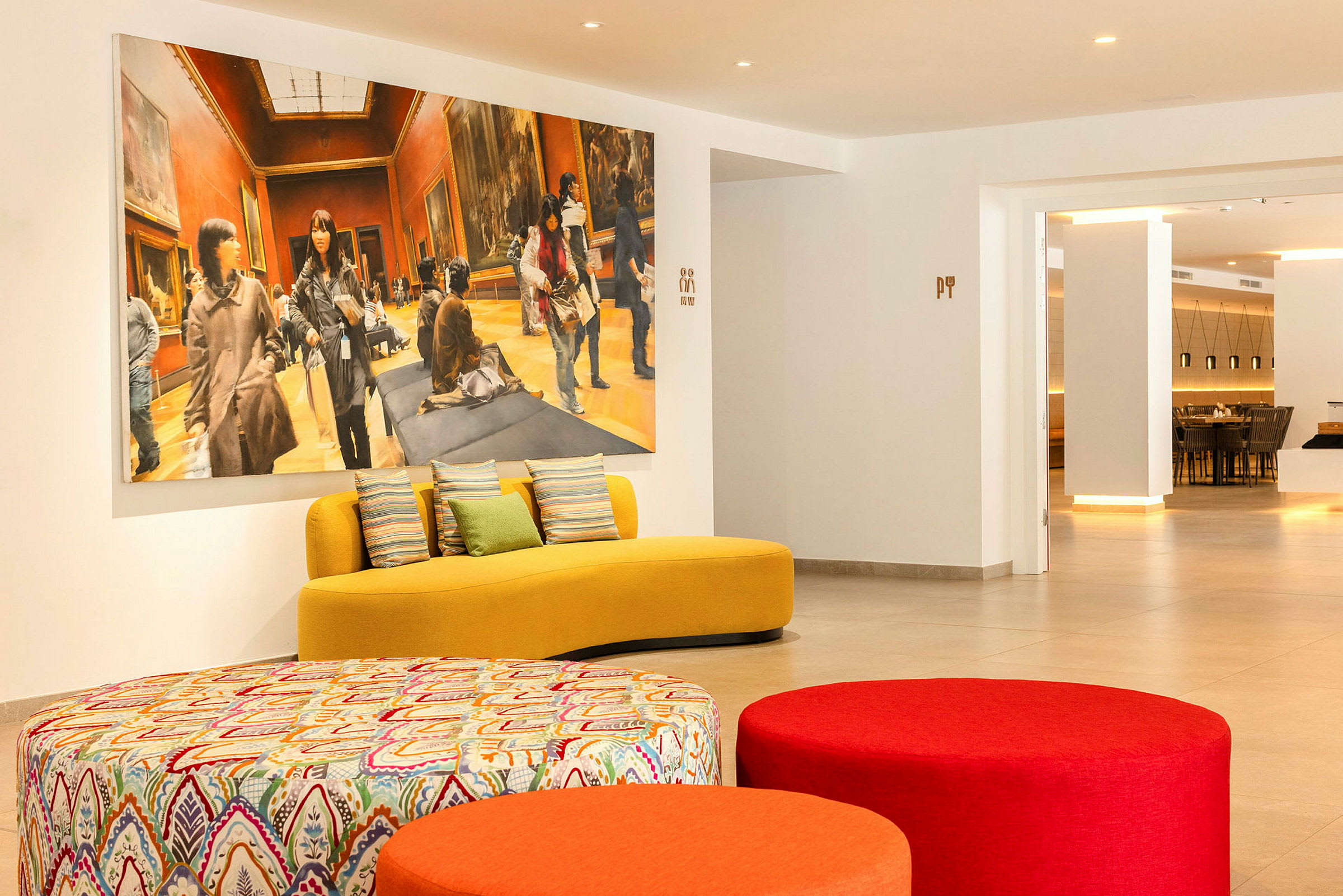 Moderni odotustila, jossa on värikkäitä istuimia ja suuri taulu seinällä. (Tekoälyn luoma teksti)