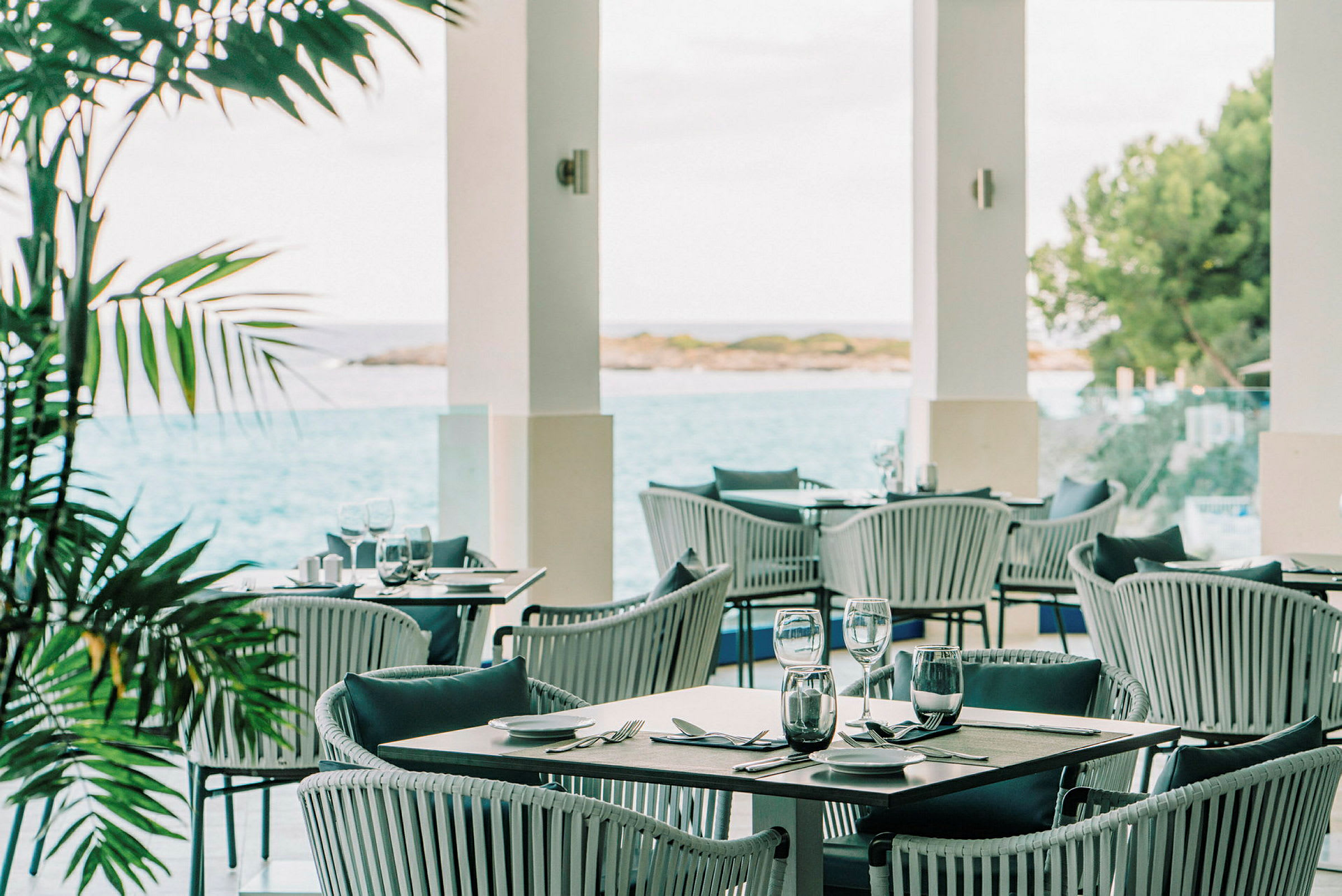 Ulkoterassiravintola, josta on näkymä merelle ja kasveihin. (Tekoälyn luoma teksti)