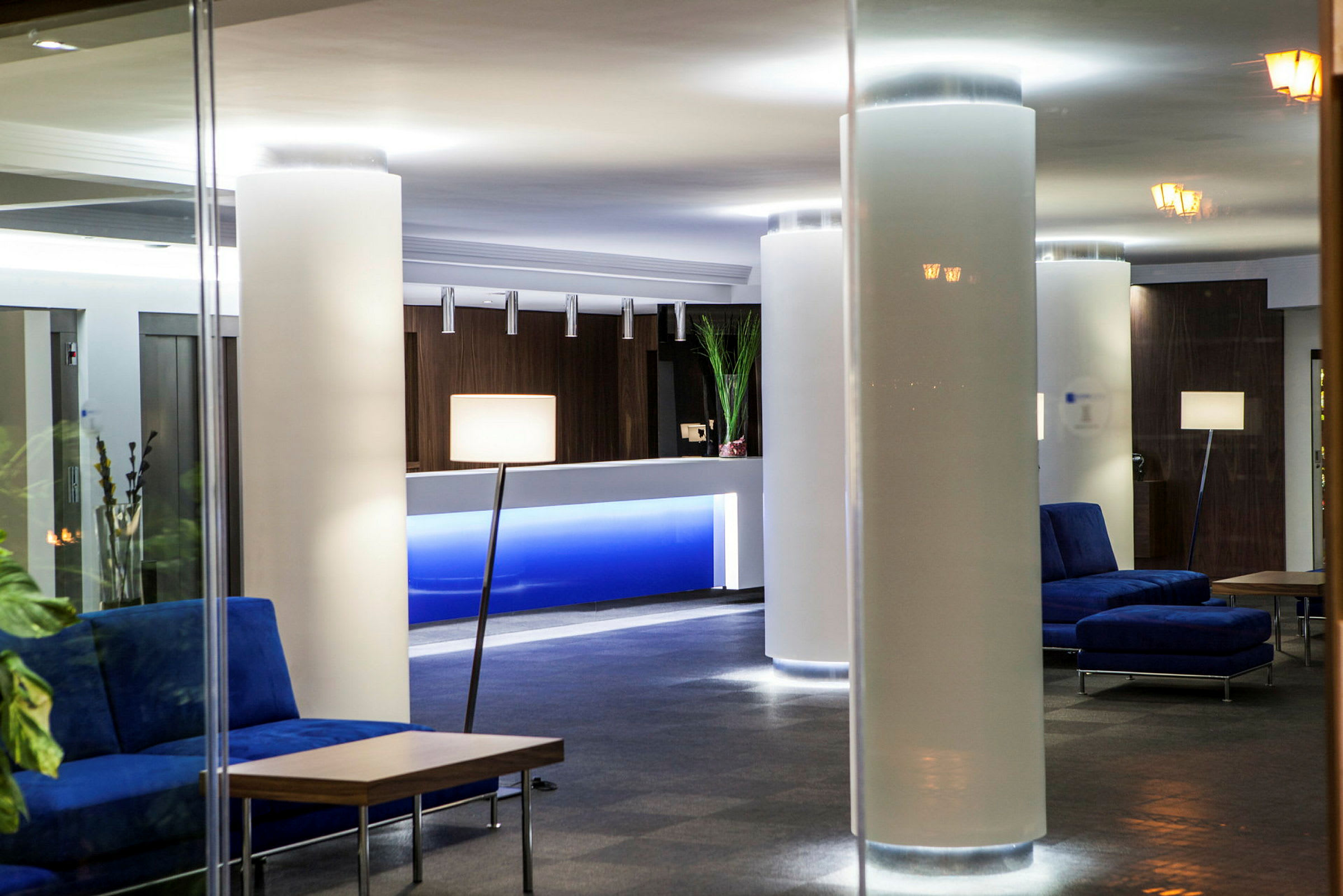 Hotelliaula, jossa on sohvia, pöytiä ja vastaanotto. (Tekoälyn luoma teksti)