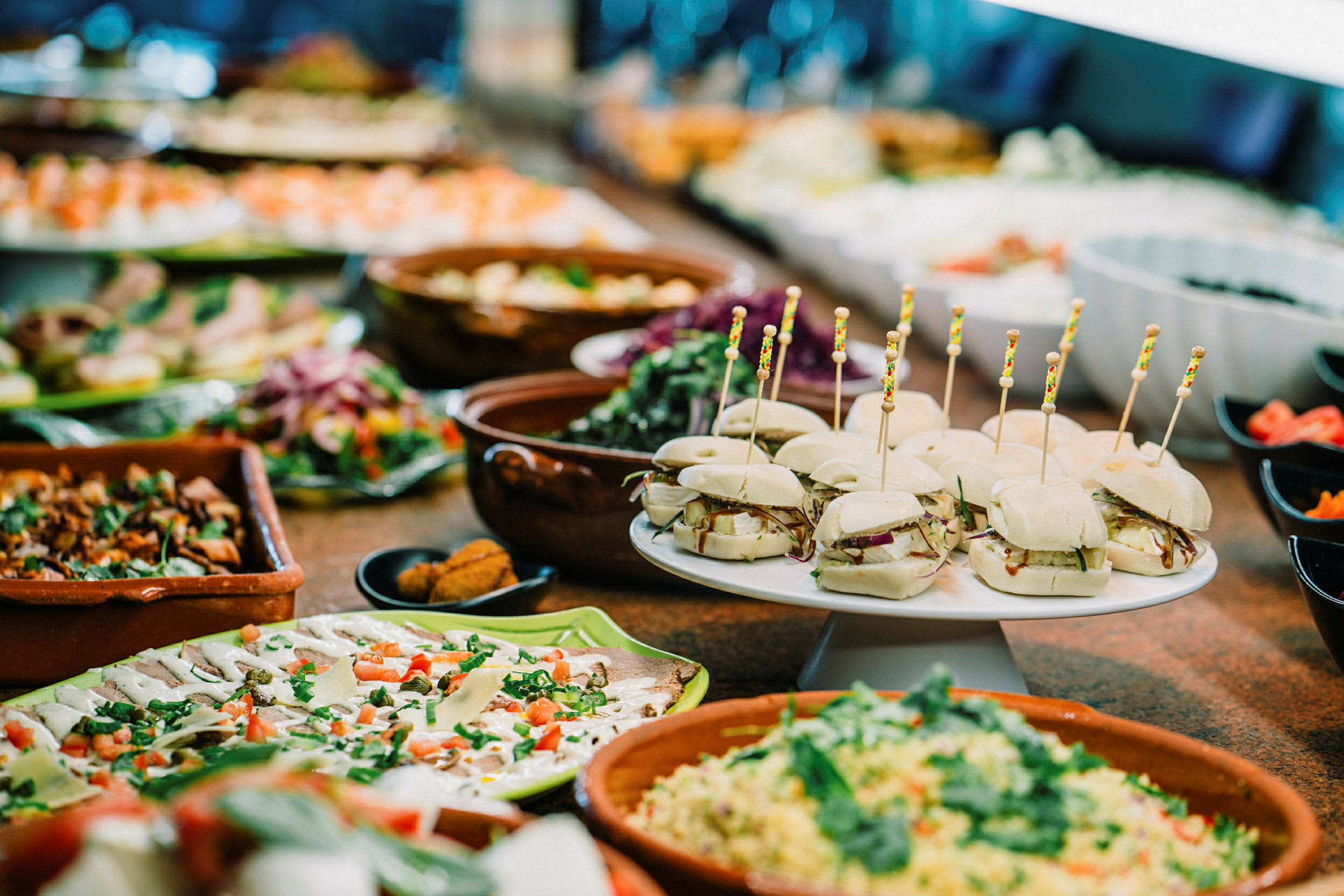 Buffet, jossa erilaisia ruokalajeja, mukaan lukien pienet voileivät ja salaatti. (Tekoälyn luoma teksti)