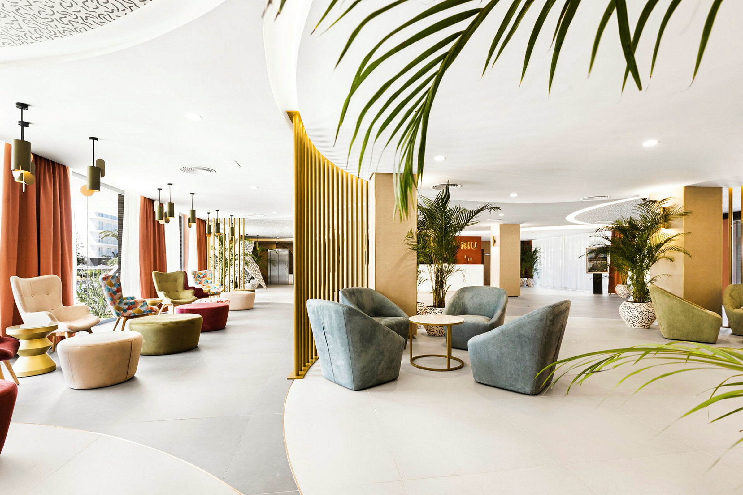 Avoin hotelliaula, jossa on nykyaikaisia huonekaluja, kasveja ja designvalaisimia. (Tekoälyn luoma teksti)