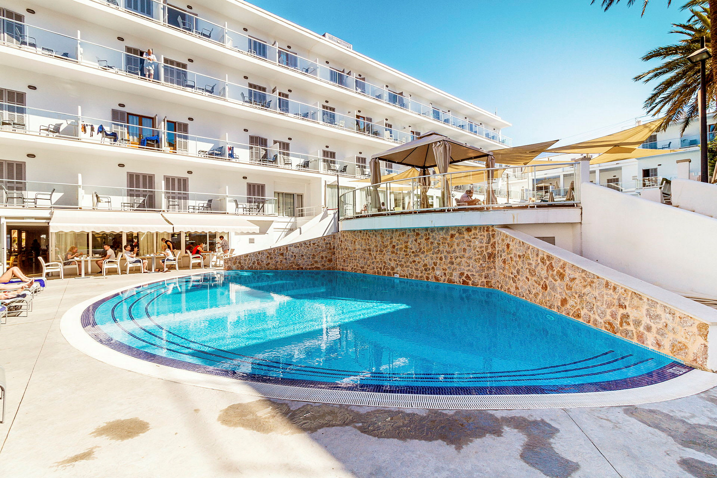 Ulkoallas hotellilla, jossa aurinkotuoleja ja parvekkeita. (Tekoälyn luoma teksti)