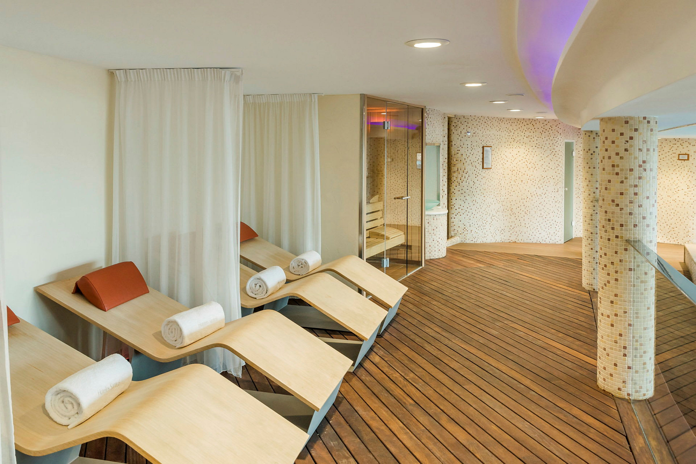 Moderni spa-rentoutumisalue, jossa puupenkit ja pyyhkeet. (Tekoälyn luoma teksti)