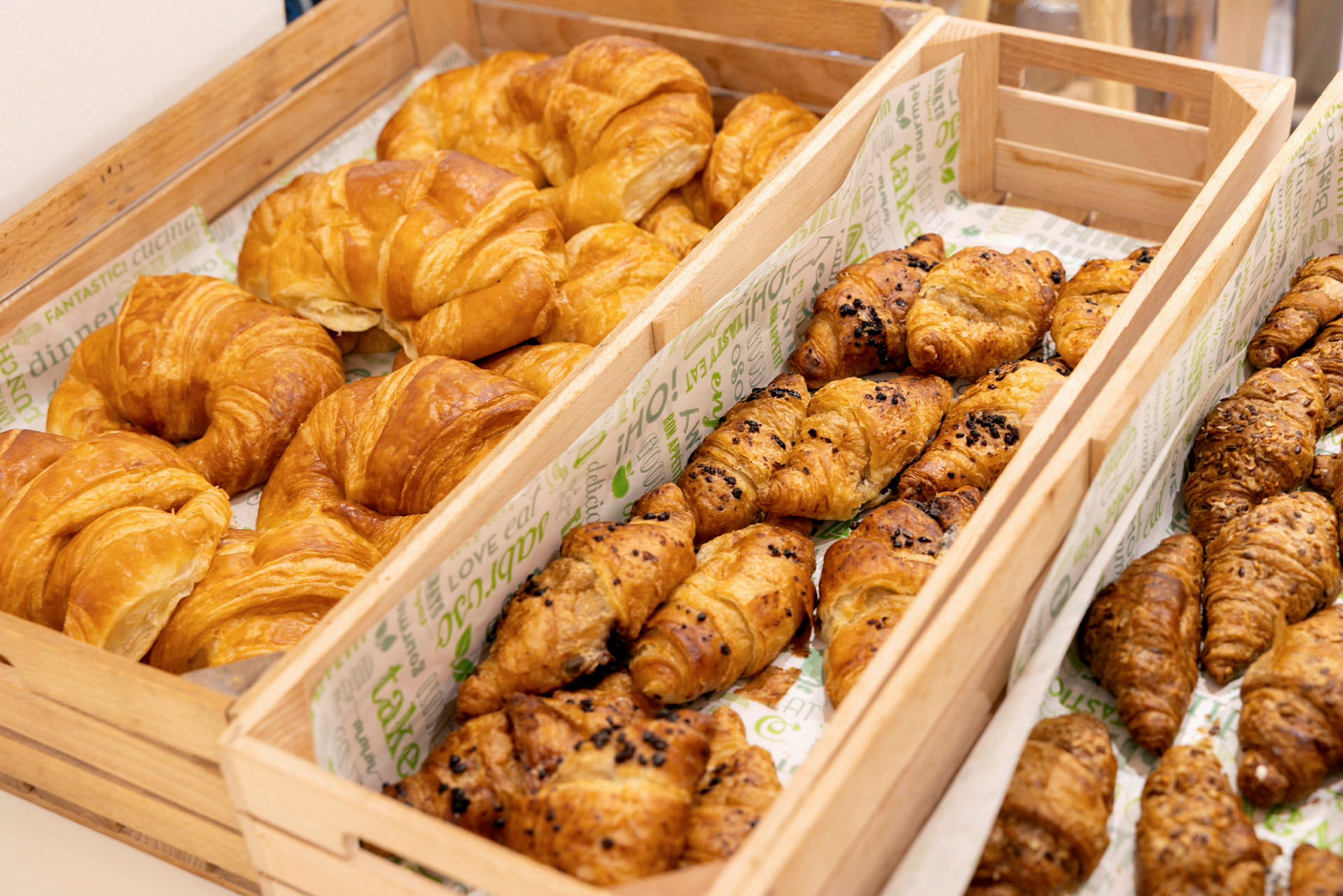 Kuva puisista koreista, jotka ovat täynnä erilaisia croissanteja. (Tekoälyn luoma teksti)
