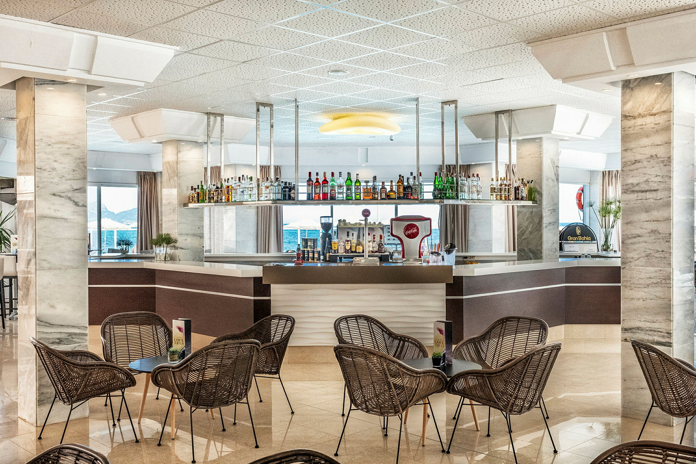 Hotellibaari, etualalla tuoleja ja pöytiä. (Tekoälyn luoma teksti)