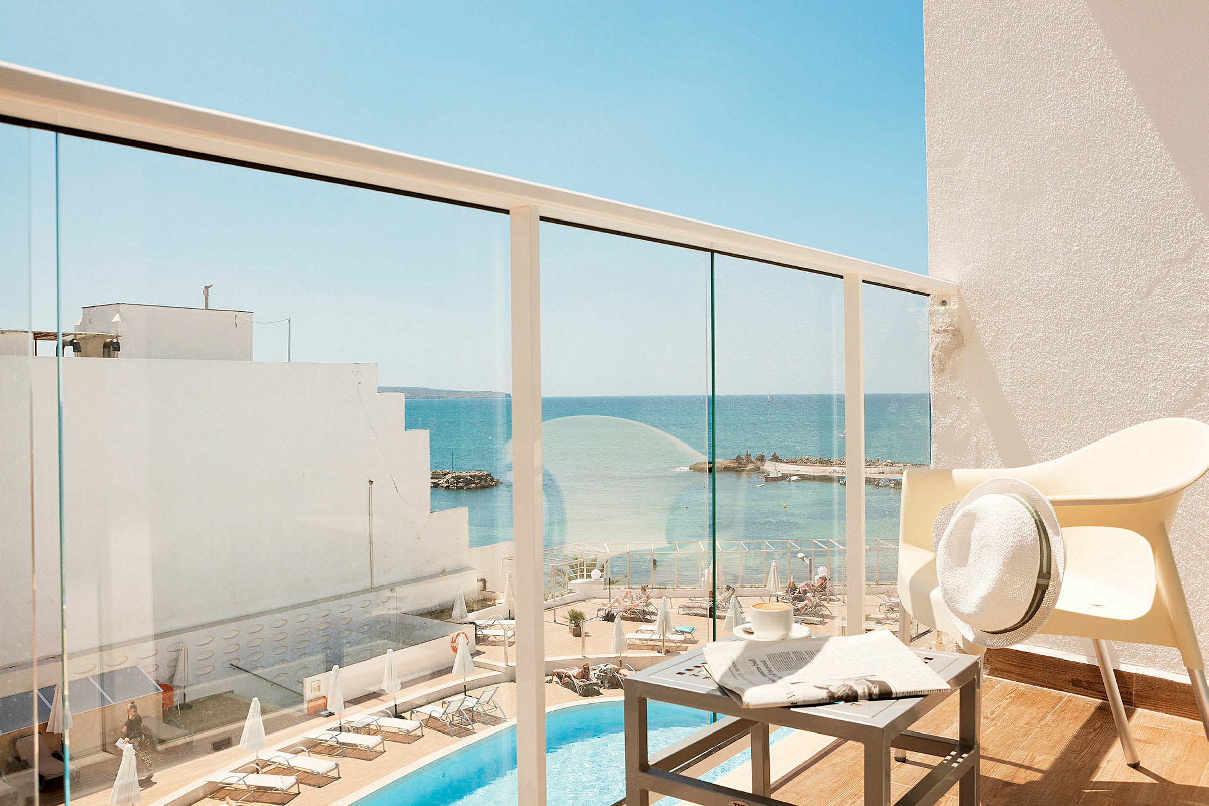 Hotellin parveke, näkymä uima-allasalueelle ja merelle. (Tekoälyn luoma teksti)