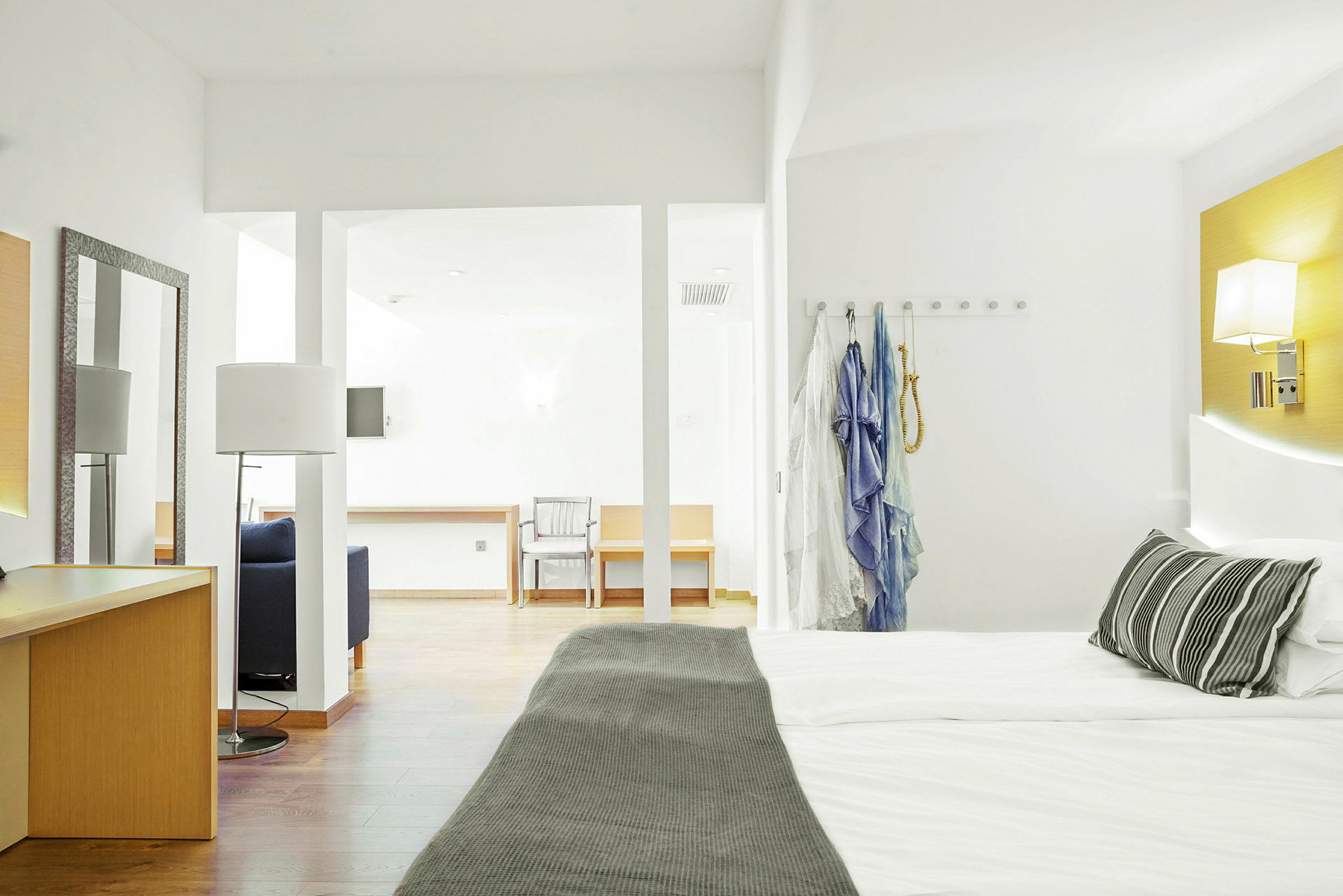 Hotellihuone, jossa on parivuode, kirjoituspöytä ja istuimia. (Tekoälyn luoma teksti)