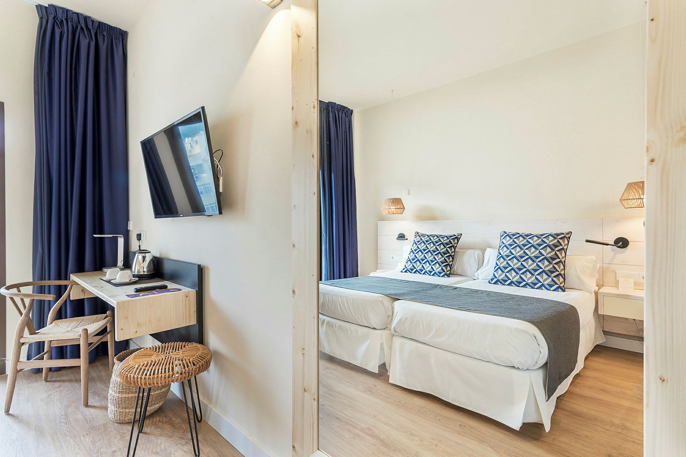 Hotellihuone, jossa kaksi sänkyä, kirjoituspöytä ja televisio. (Tekoälyn luoma teksti)