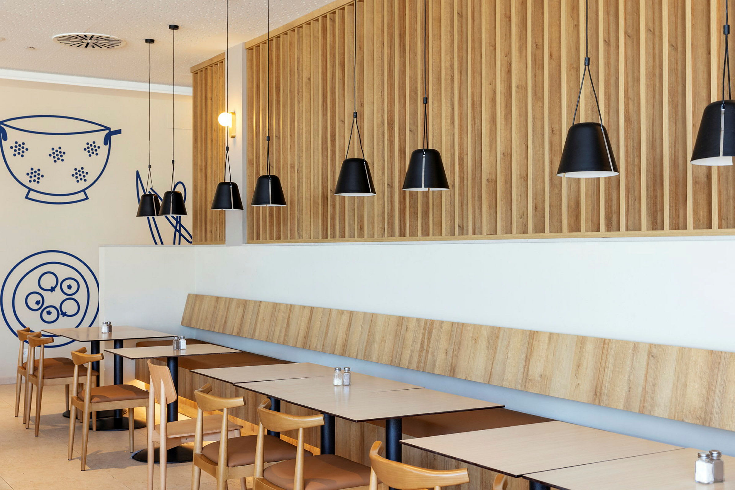 Moderni ravintola puupaneeleilla ja mustilla riippuvalaisimilla. (Tekoälyn luoma teksti)