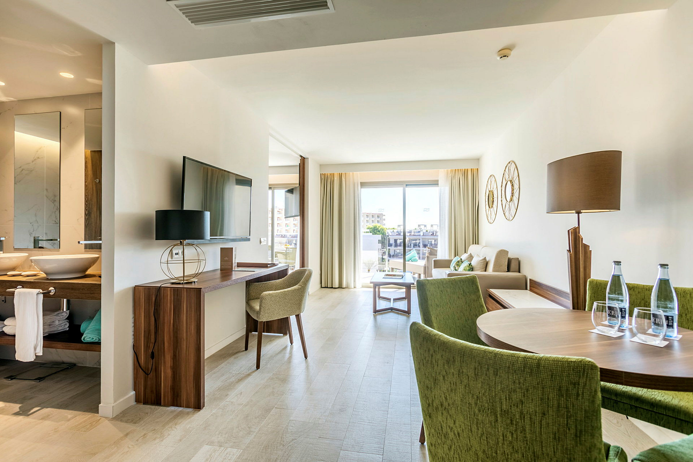 Moderni hotellihuone, jossa on istuma-alue ja ruokailutila. (Tekoälyn luoma teksti)