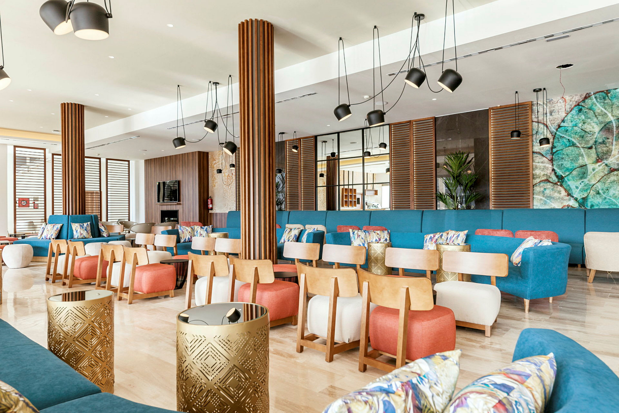 Tilava ja hyvin sisustettu lounge-tila värikkäillä huonekaluilla ja modernilla sisustuksella. (Tekoälyn luoma teksti)