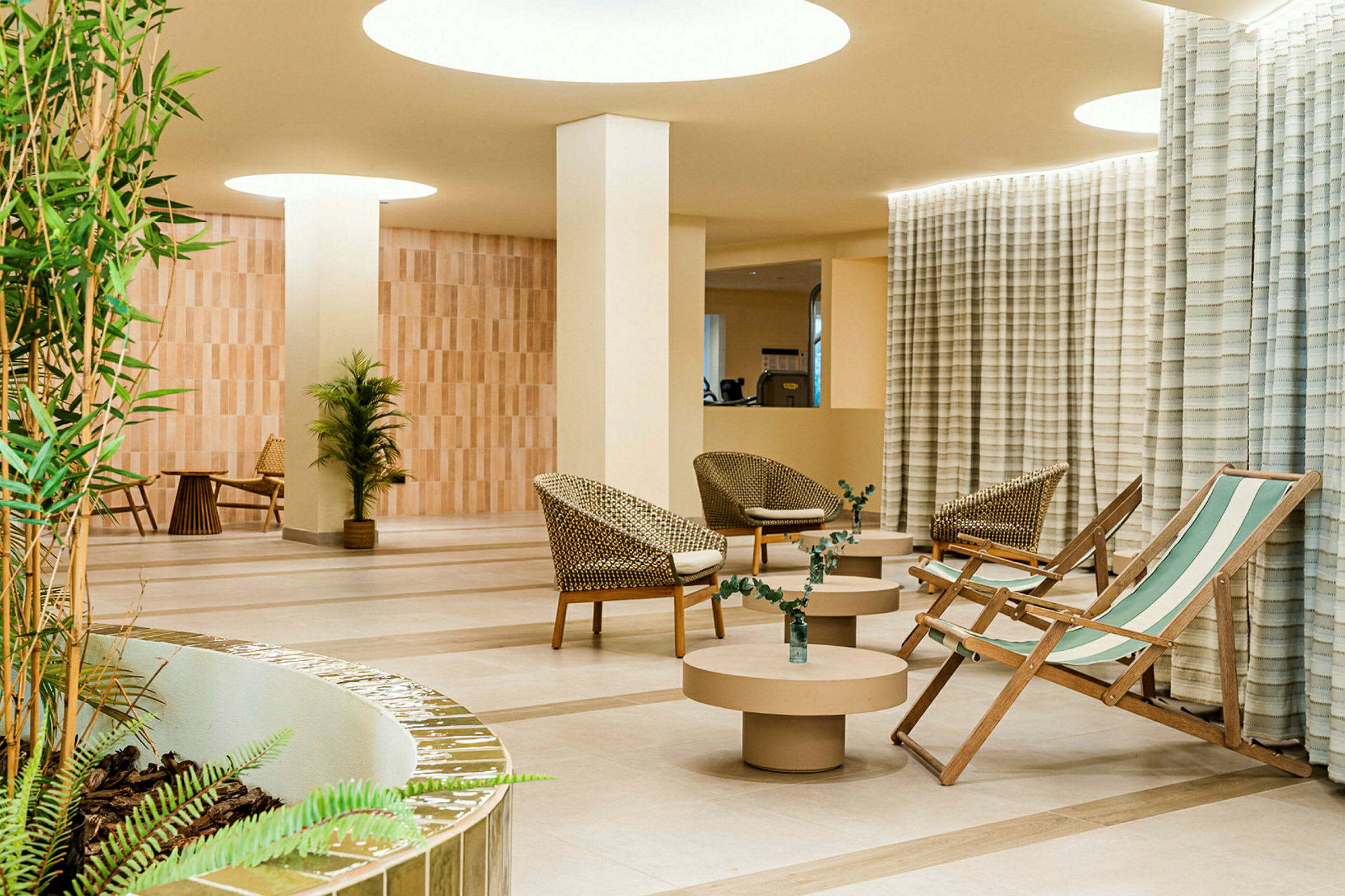 Valoisa ja moderni lounge, jossa istuimia ja kasveja. (Tekoälyn luoma teksti)