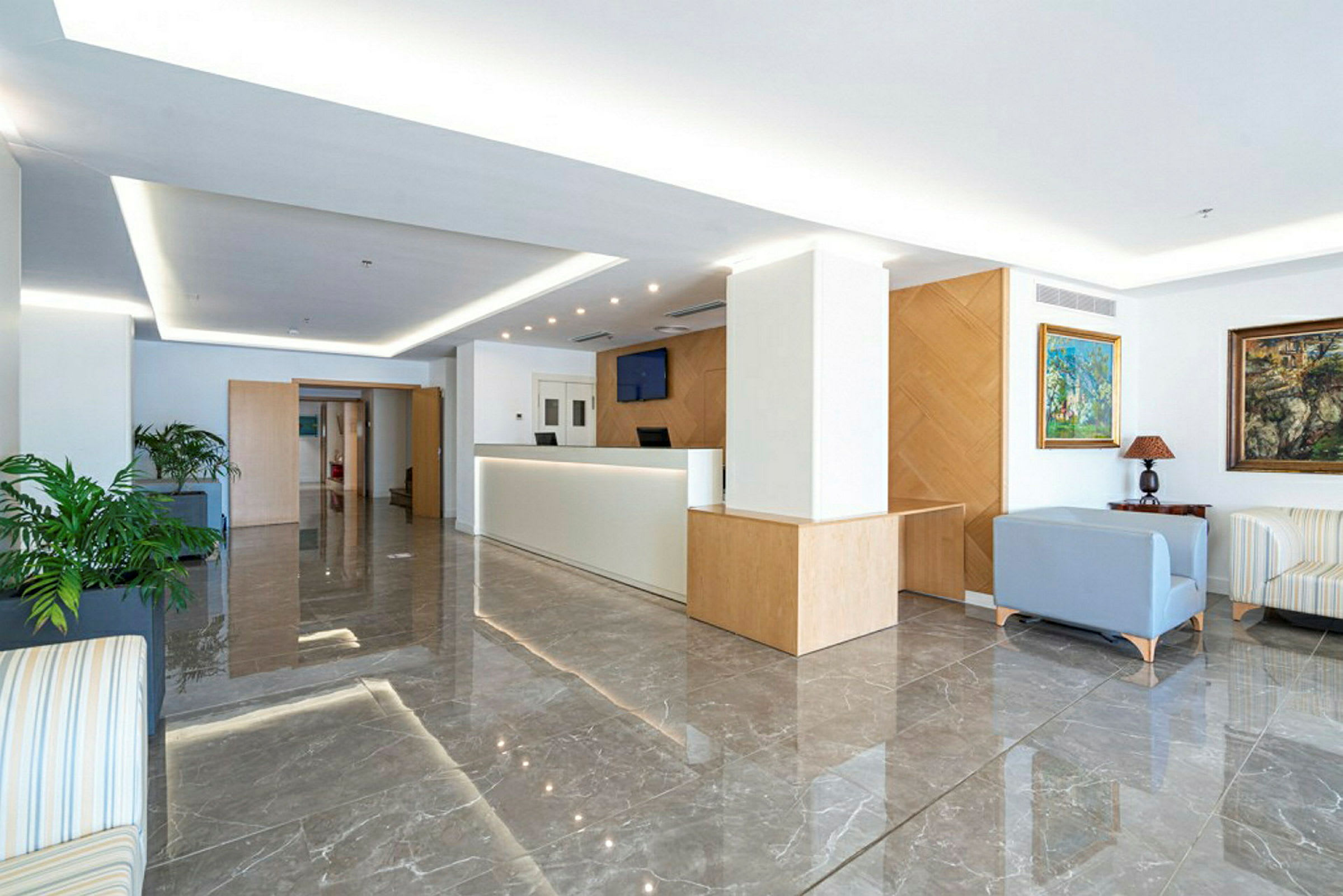 Moderni ja valoisa hotellialue, jossa vastaanotto ja istuinryhmä. (Tekoälyn luoma teksti)