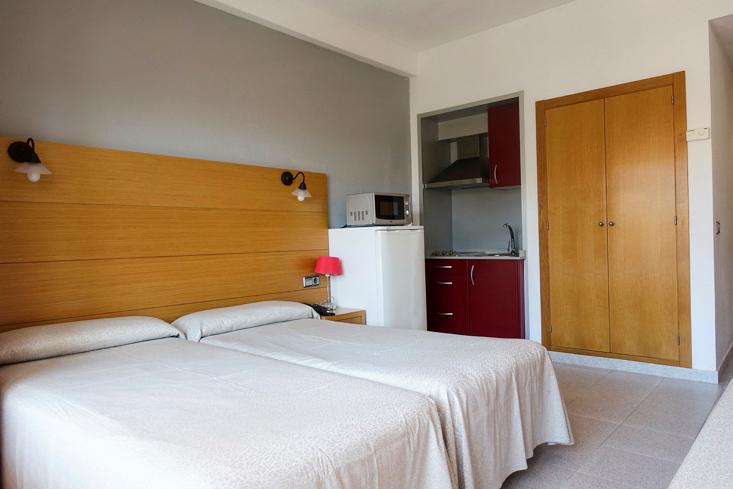 Hotellihuone, jossa kaksi erillistä vuodetta, pieni keittonurkkaus ja vaatekaappi. (Tekoälyn luoma teksti)