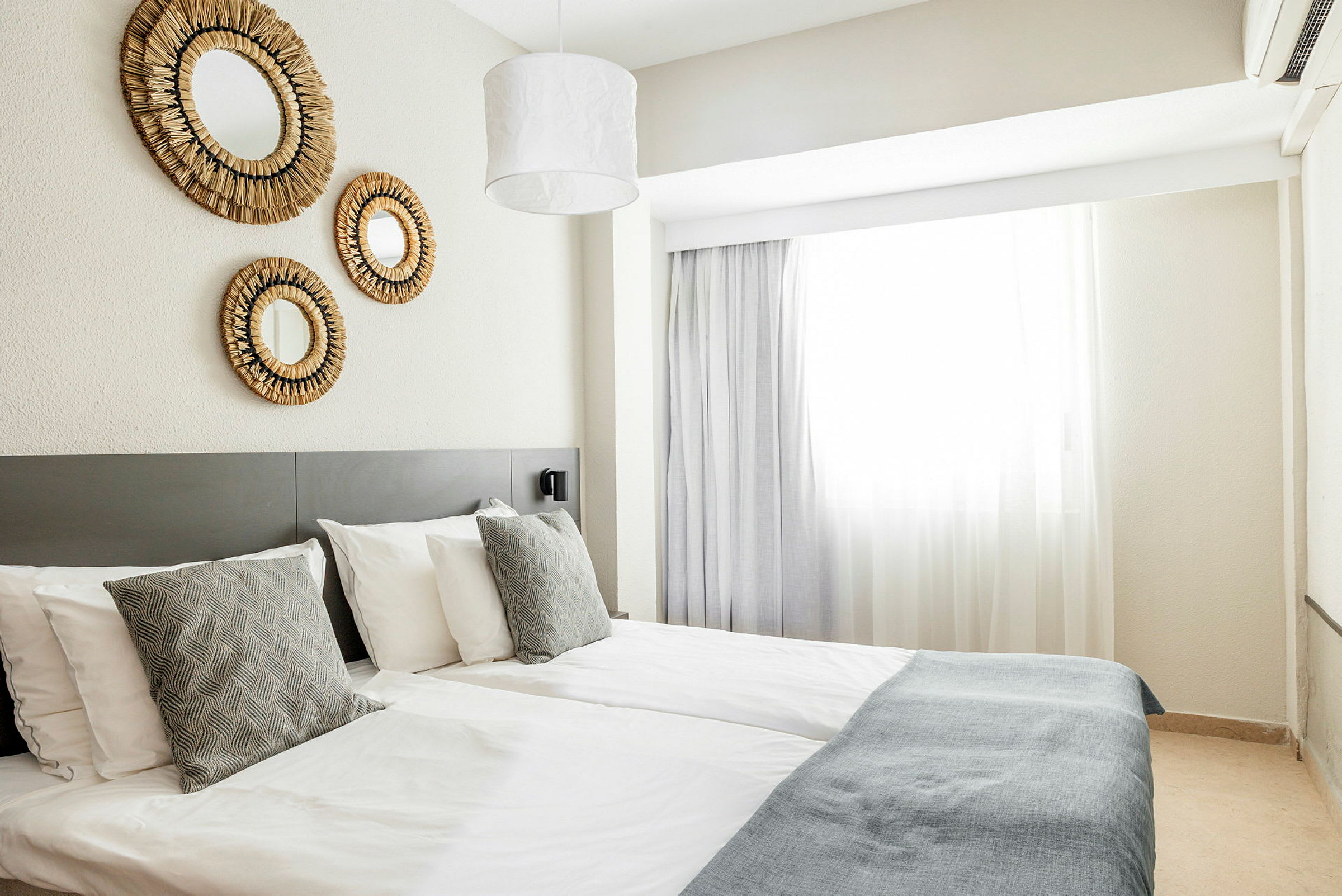 Hotellihuone, jossa kaksi erillistä vuodetta ja seinäkoristeita. (Tekoälyn luoma teksti)
