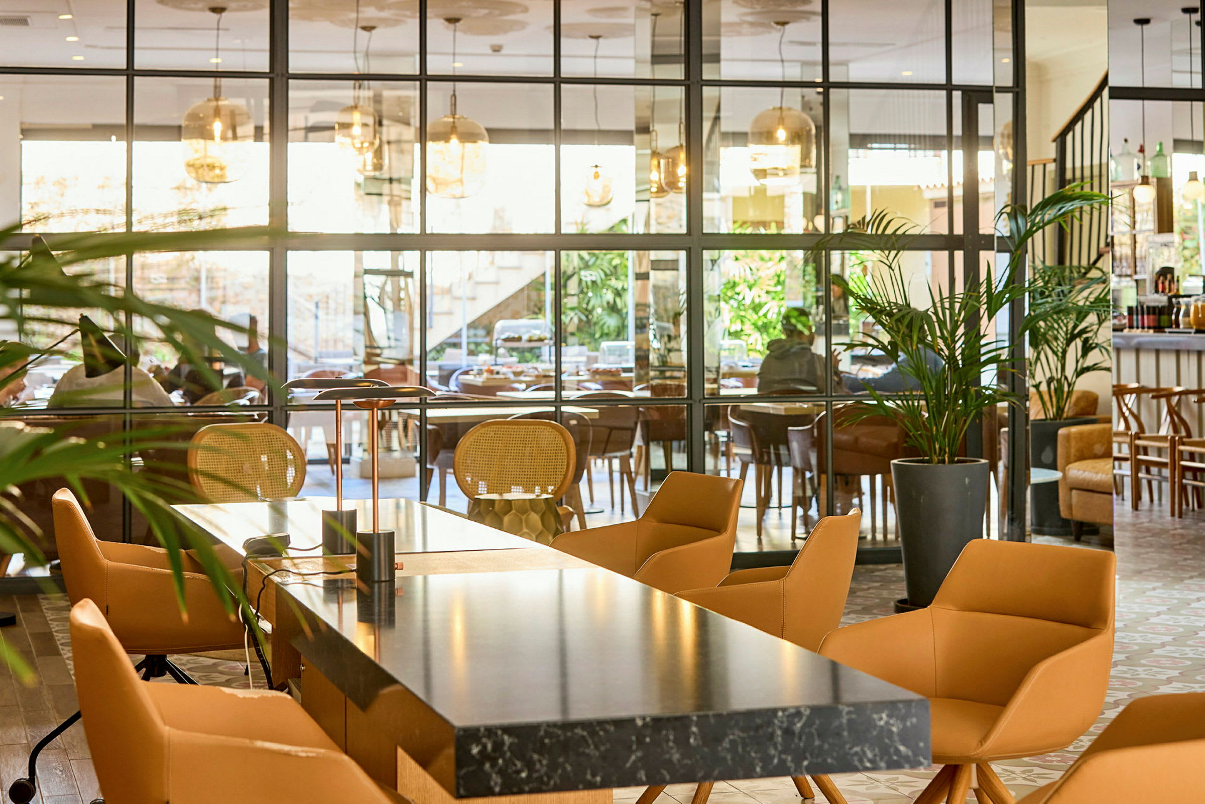 Moderni sisustettu hotellialue, jossa istumapaikkoja ja lasiseiniä. (Tekoälyn luoma teksti)