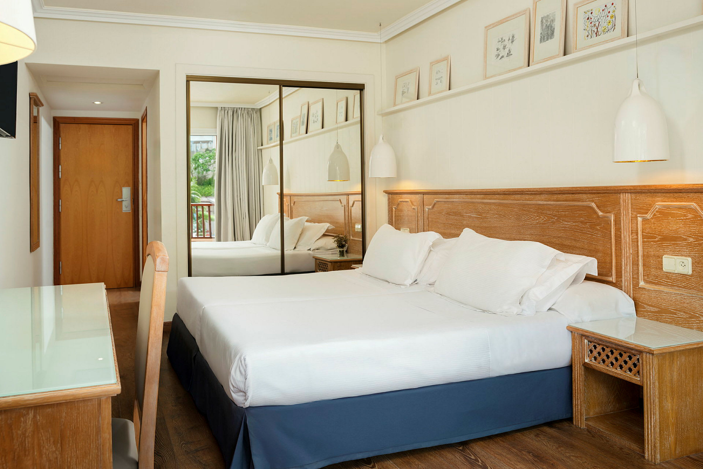 Hotellihuone, jossa on parivuode, puuyksityiskohtia ja peiliovet. (Tekoälyn luoma teksti)