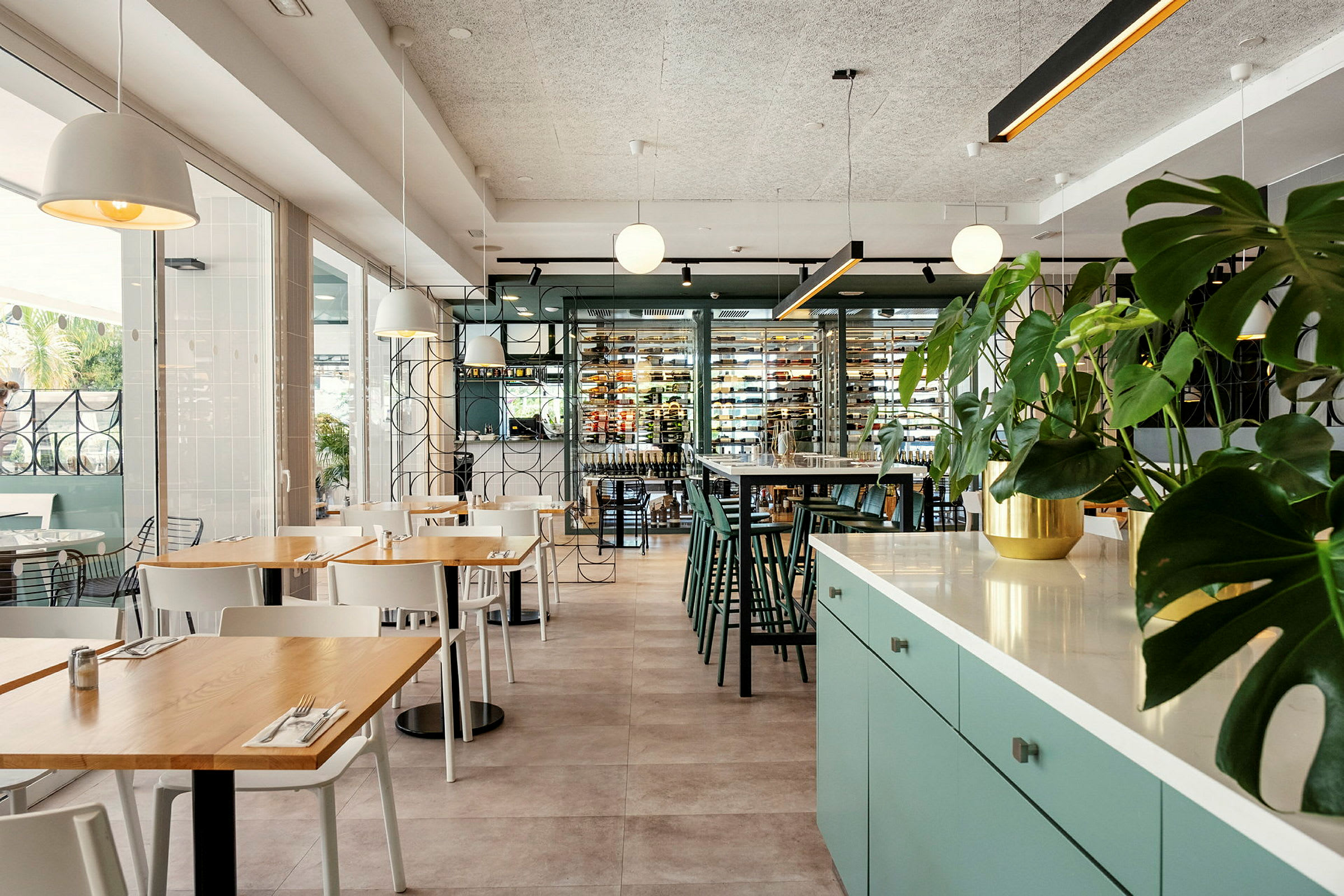 Modernin ravintolan sisustus, jossa on istuinryhmiä ja vihreitä kasveja. (Tekoälyn luoma teksti)