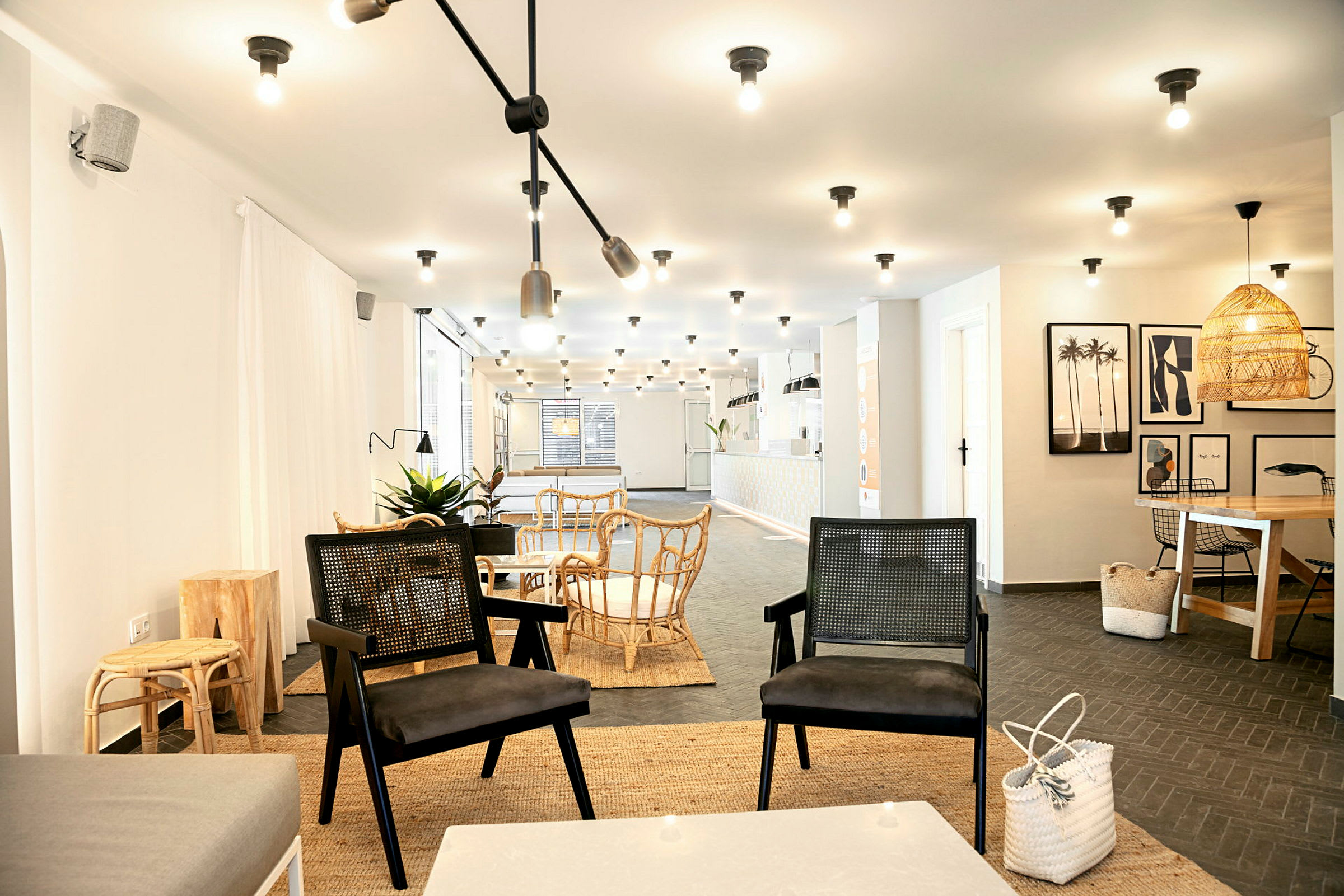 Modernisti sisustettu lounge, jossa on pöytiä ja tuoleja valoisassa ympäristössä. (Tekoälyn luoma teksti)