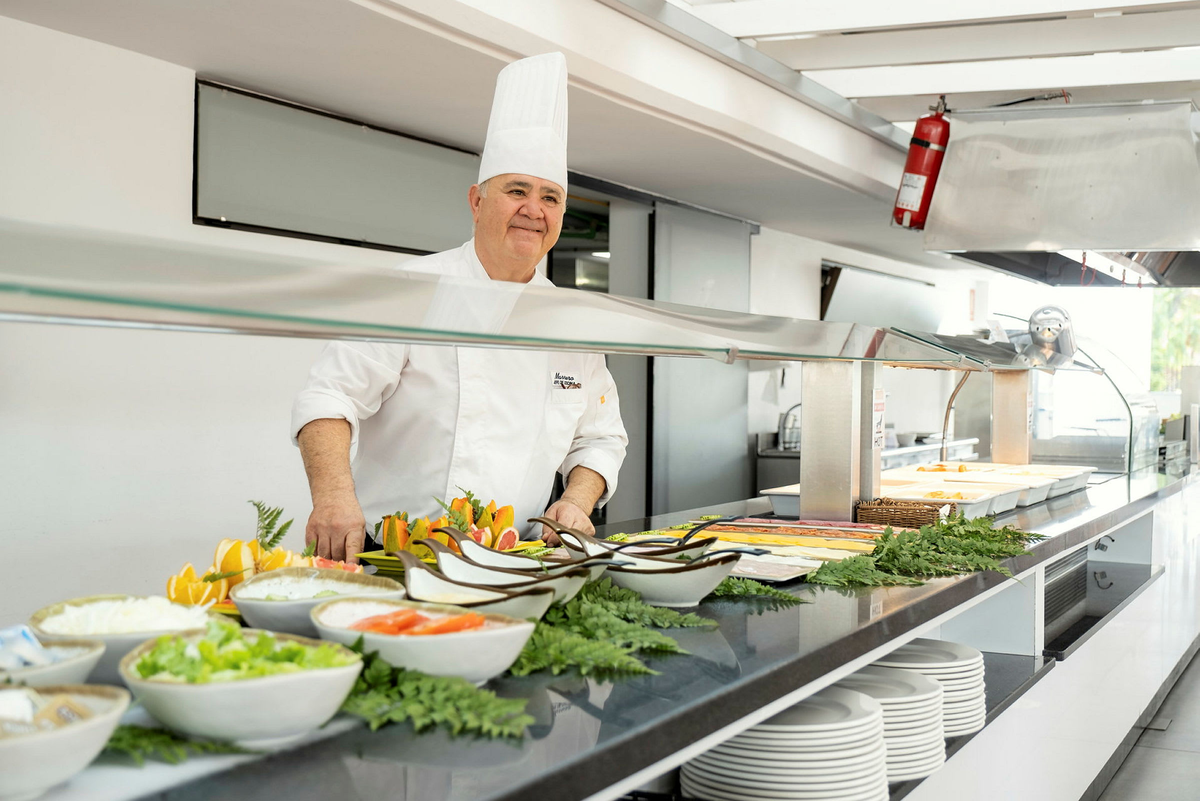 Buffet-alue kokki valkoisessa univormussa. (Tekoälyn luoma teksti)