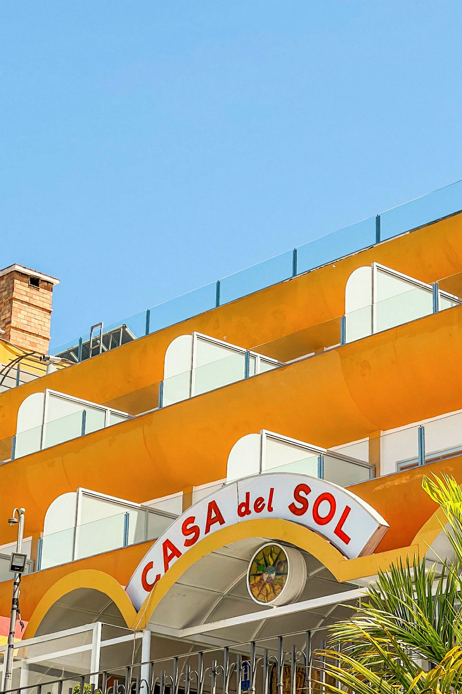 Rakennus, jossa on keltaiset parvekkeet ja kyltti, jossa lukee "Casa del Sol". (Tekoälyn luoma teksti)