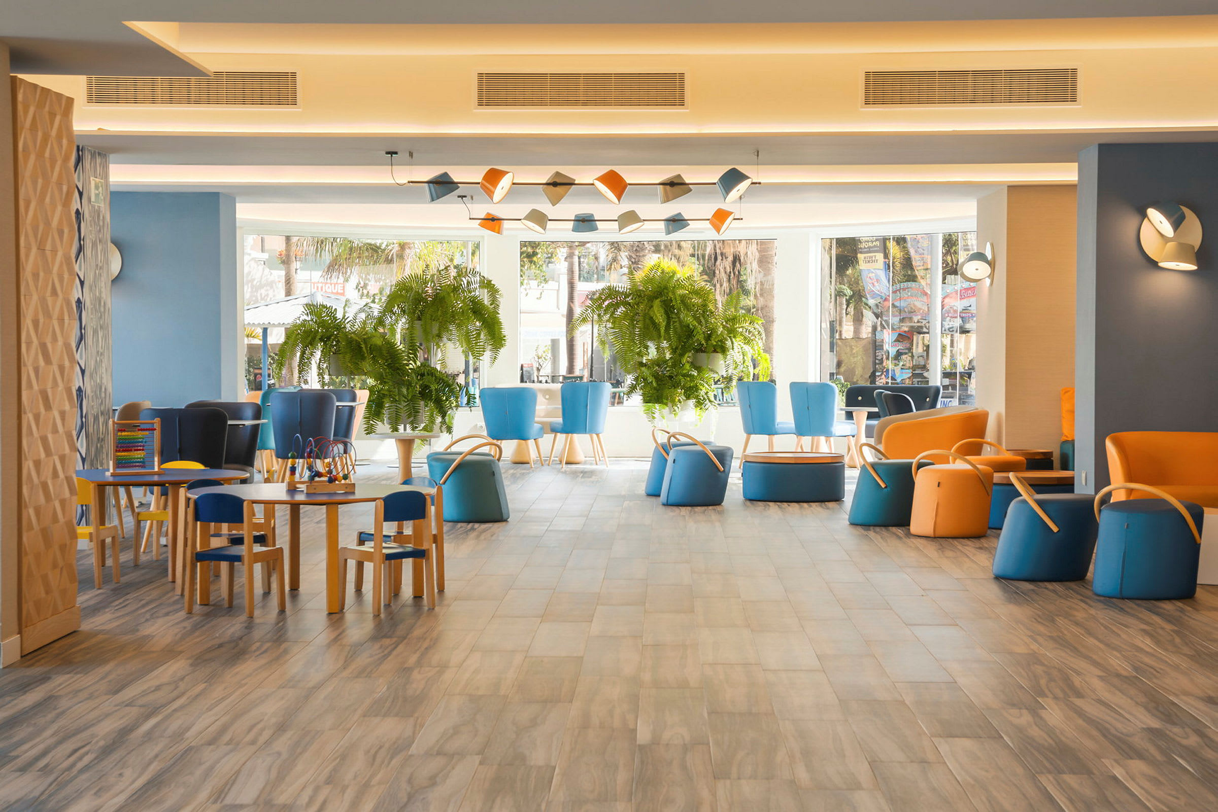 Värikäs hotellialue, jossa on istumapaikkoja ja kasveja. (Tekoälyn luoma teksti)