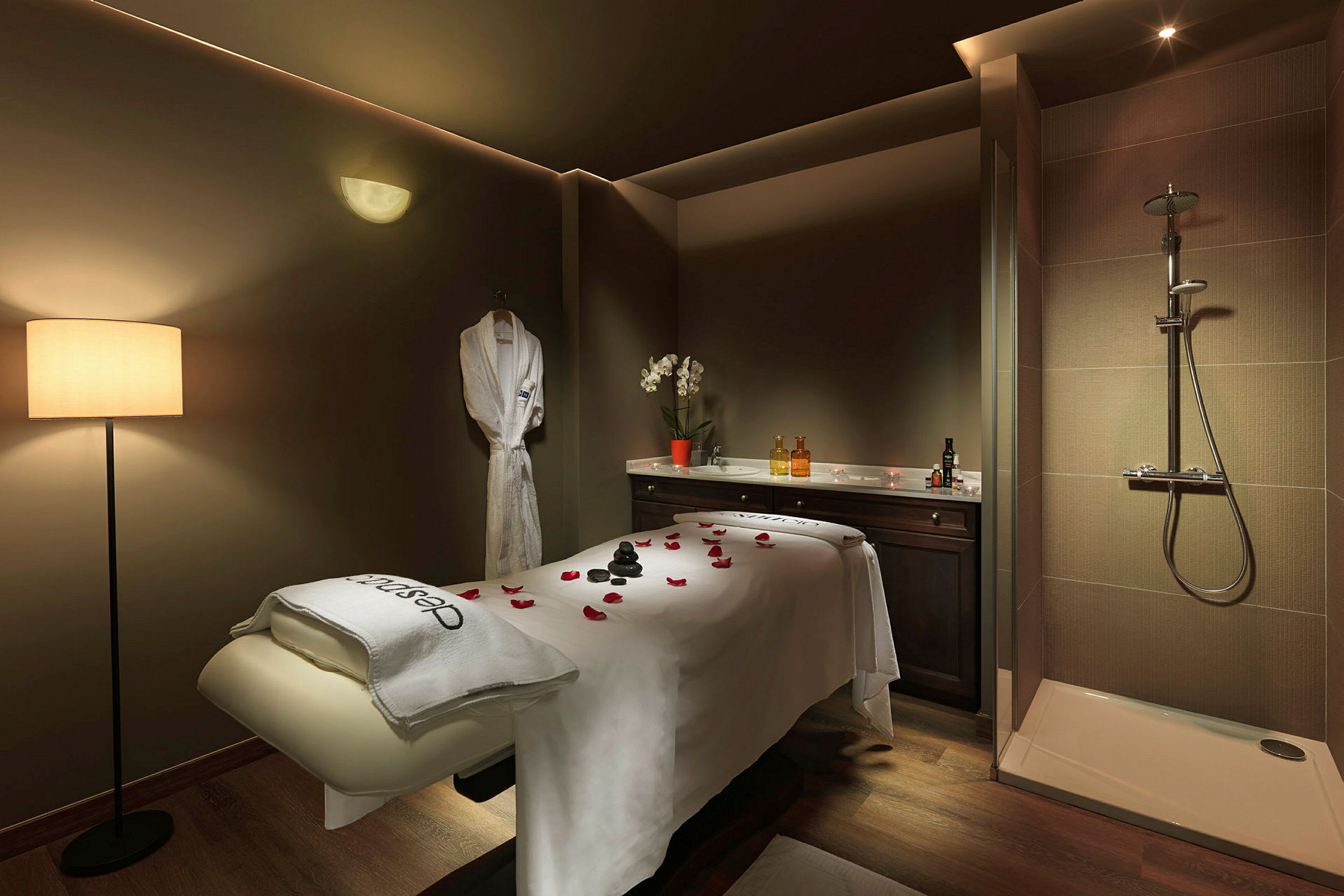 Spa- tai hierontahoitohuone, jossa hoitopenkki, suihku ja seinälle ripustettu kylpytakki. (Tekoälyn luoma teksti)
