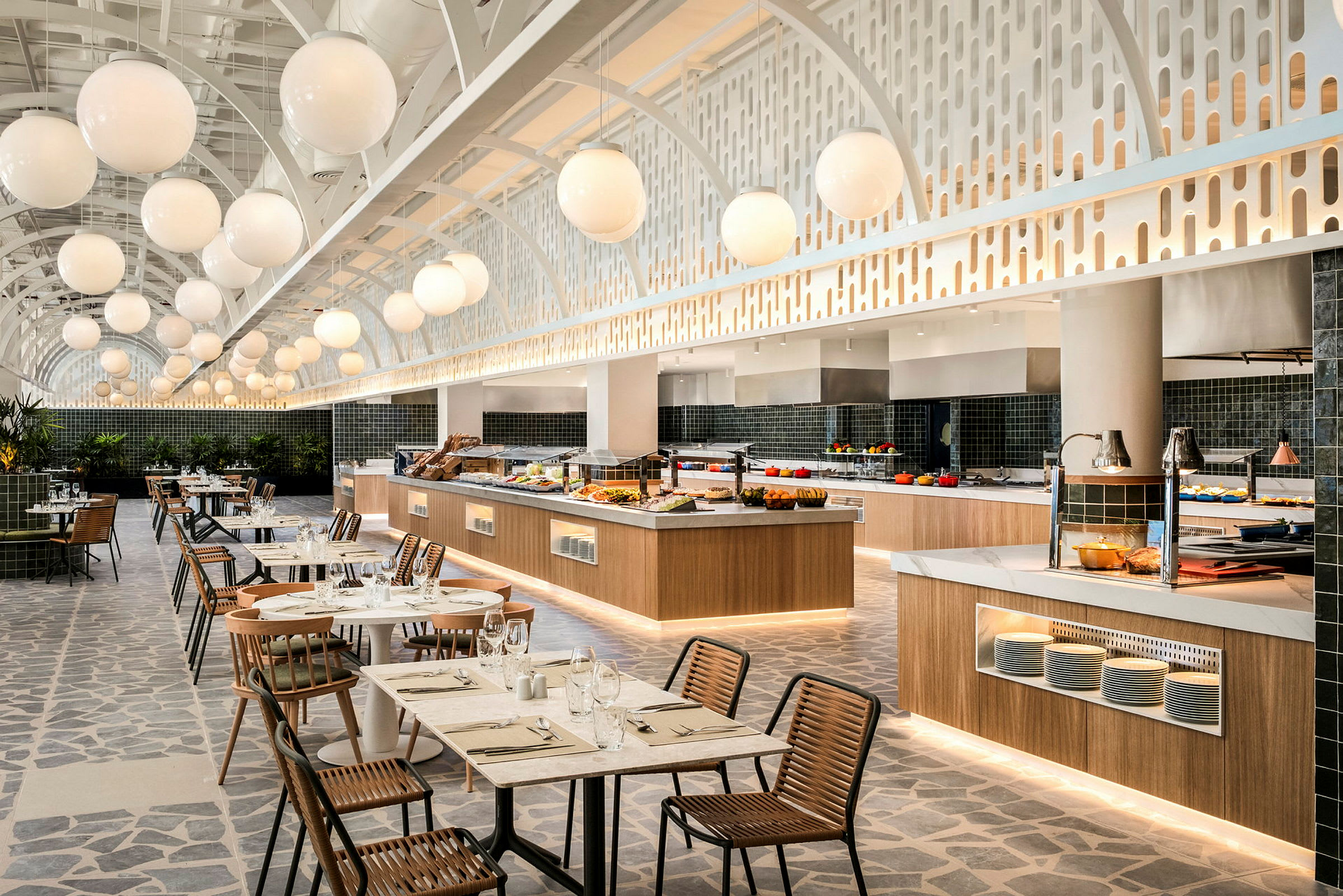 Sisäkuva tyylikkäästä buffet-ravintolasta, jossa katetut pöydät ja modernit yksityiskohdat. (Tekoälyn luoma teksti)
