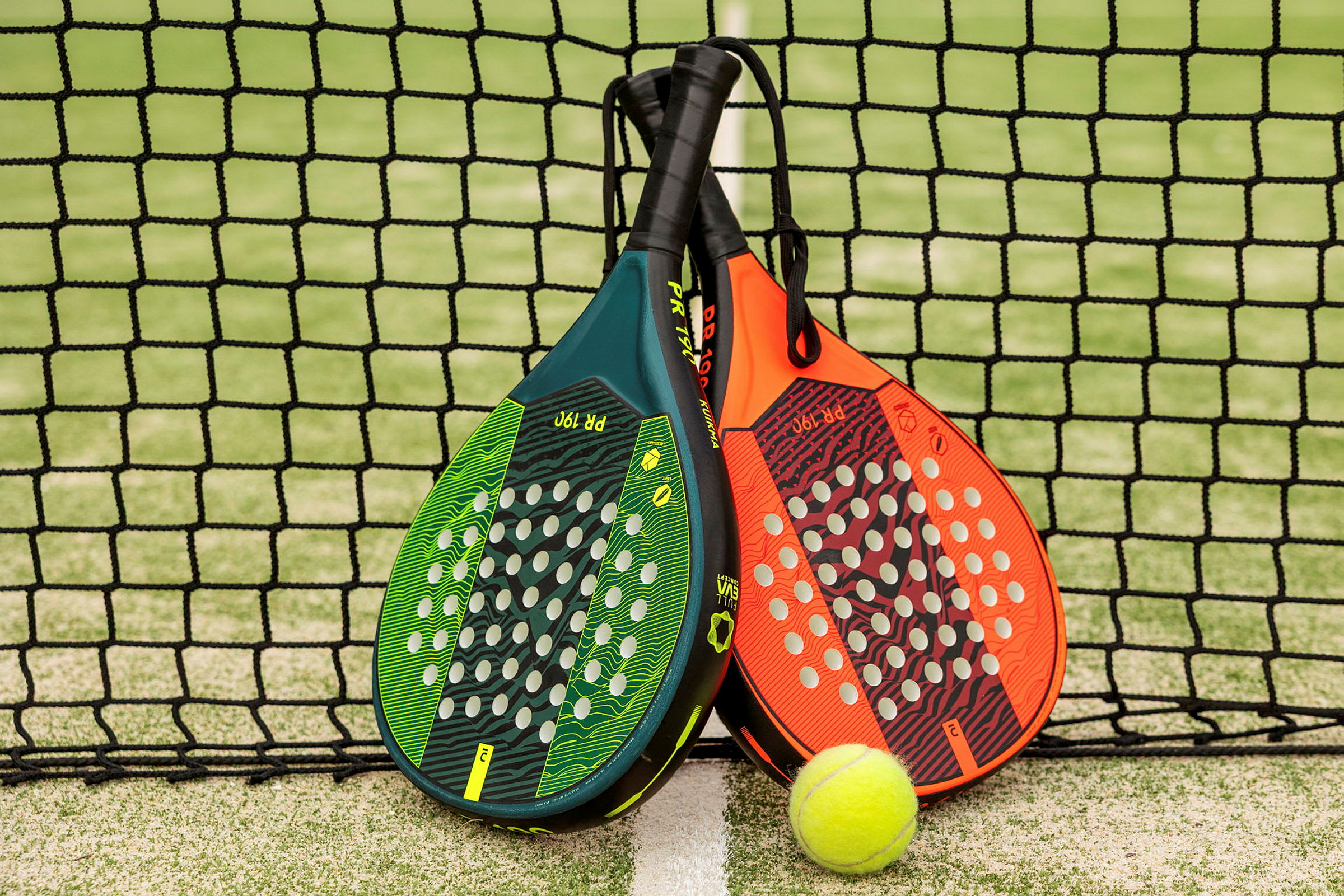 Kaksi padelmailaa ja pallo verkon edessä. (Tekoälyn luoma teksti)