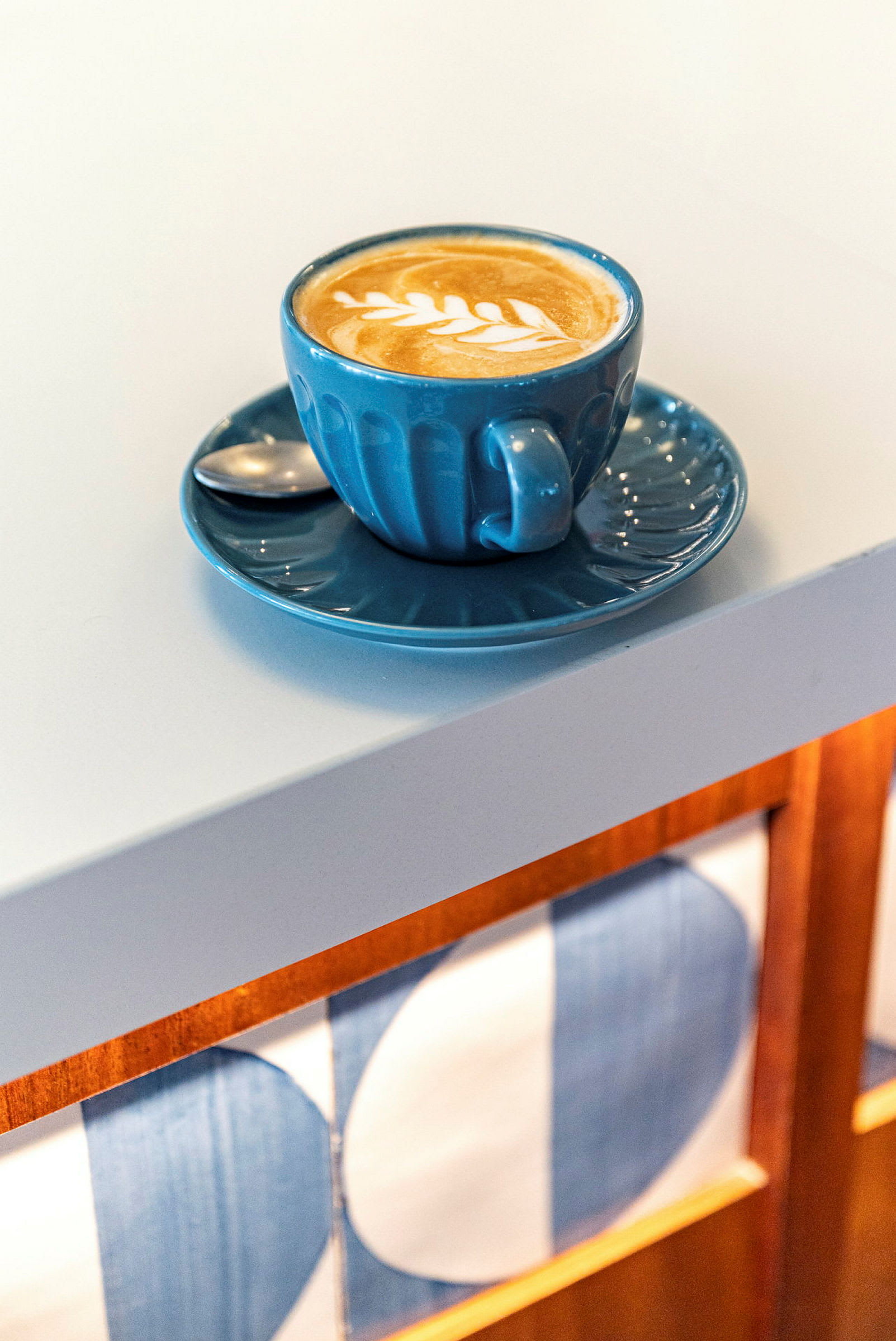 Kahvikuppi latte-taiteella valkoisella pöydällä. (Tekoälyn luoma teksti)