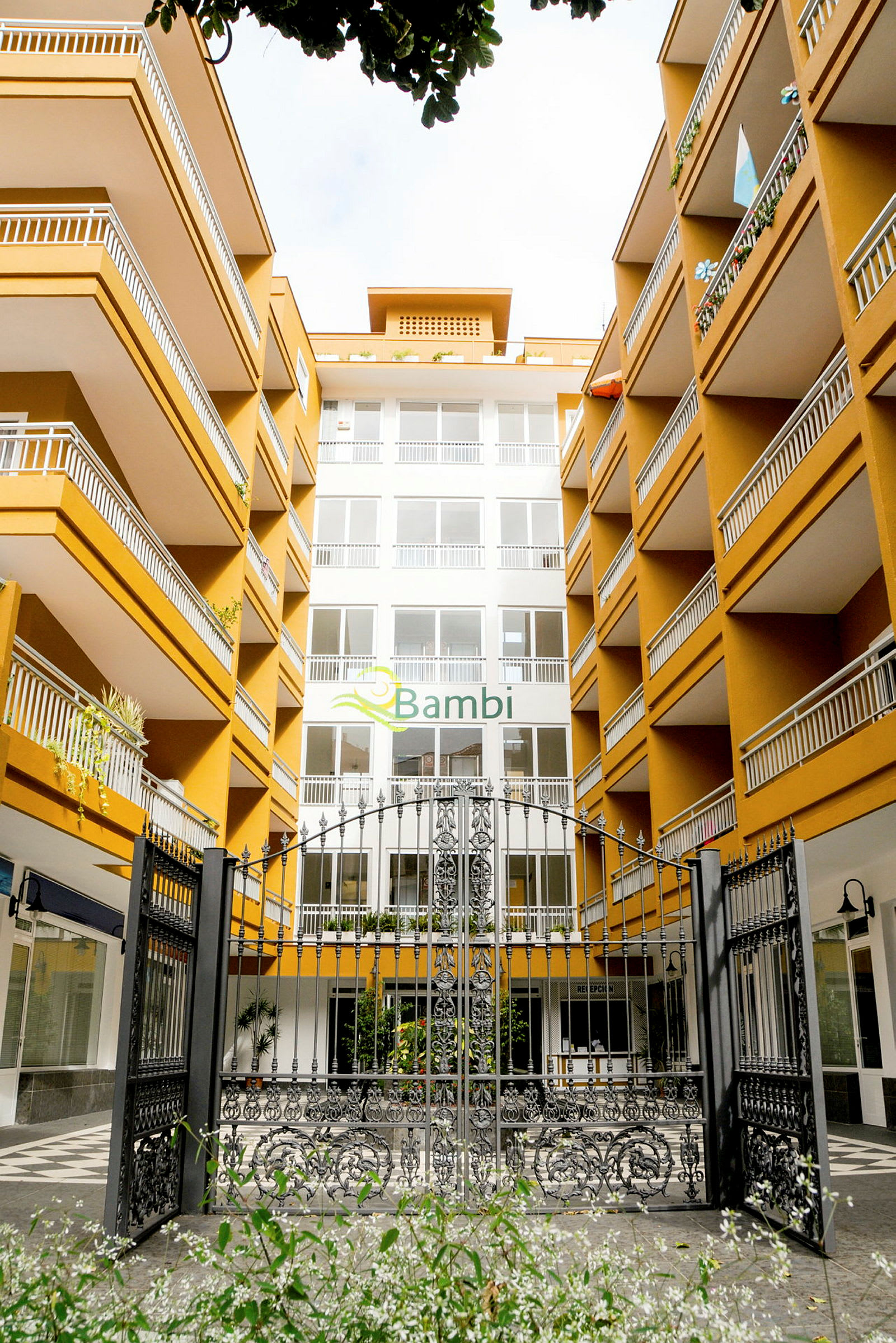 Sisäänkäynti hotellikompleksiin, jossa useita kerroksia ja parvekkeita. (Tekoälyn luoma teksti)