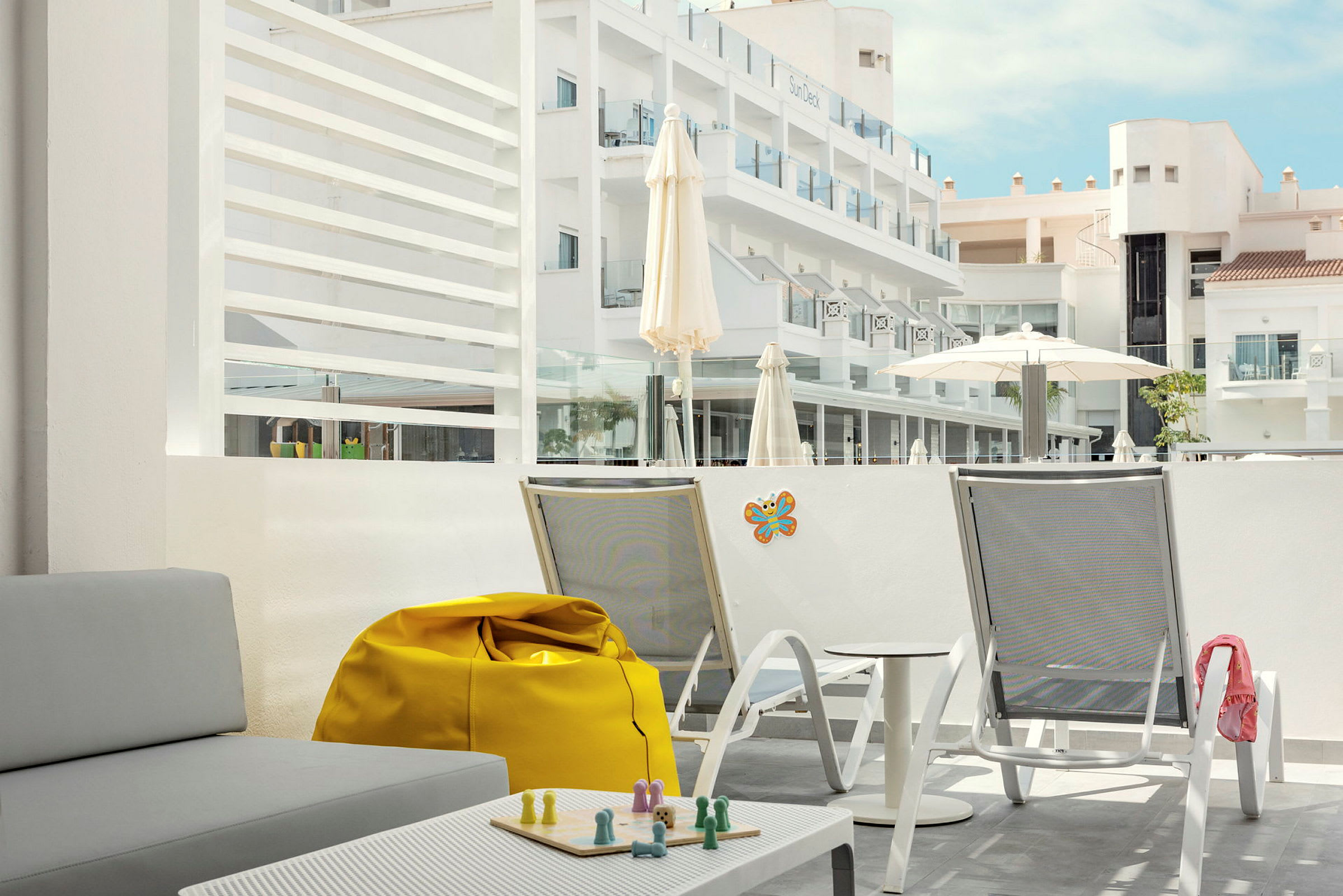 Kuva hotelliterassilta, jolla on istuimia ja näkymä rakennuksiin. (Tekoälyn luoma teksti)