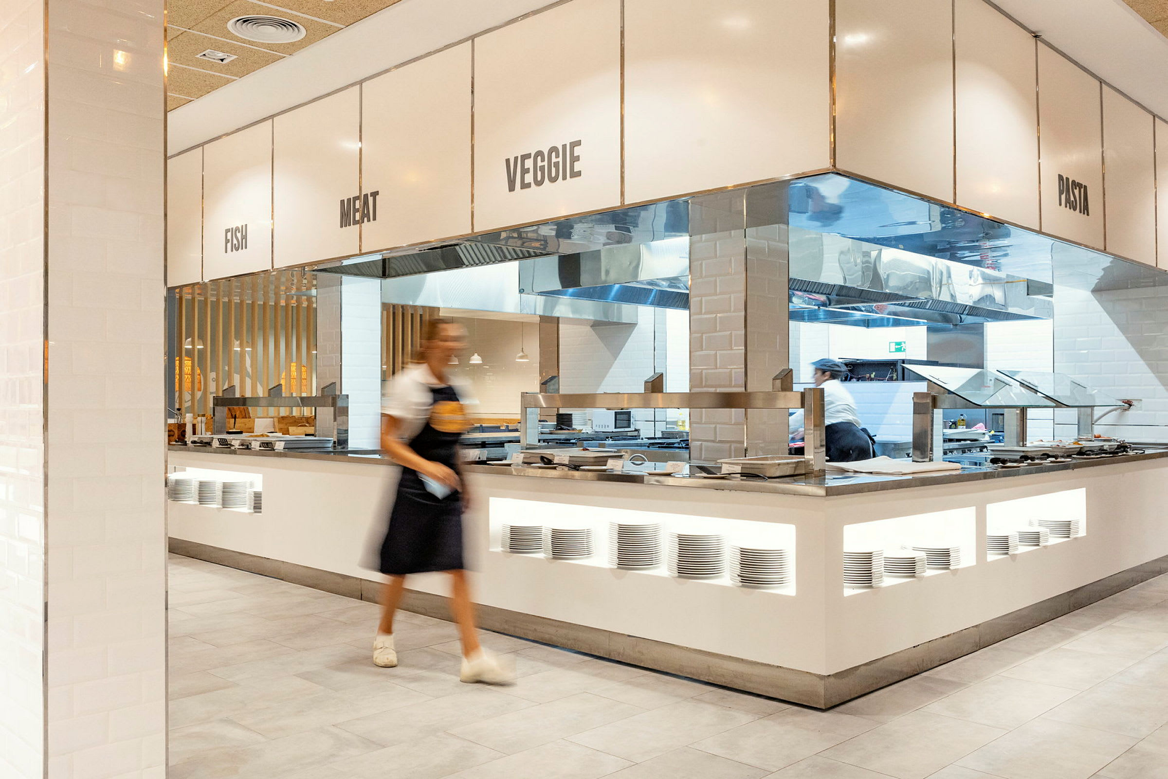 Buffet-alue, jossa on eri ruokapisteitä. Kyltti ilmoittaa kategorioita kuten kala, liha, kasvis ja pasta. (Tekoälyn luoma teksti)