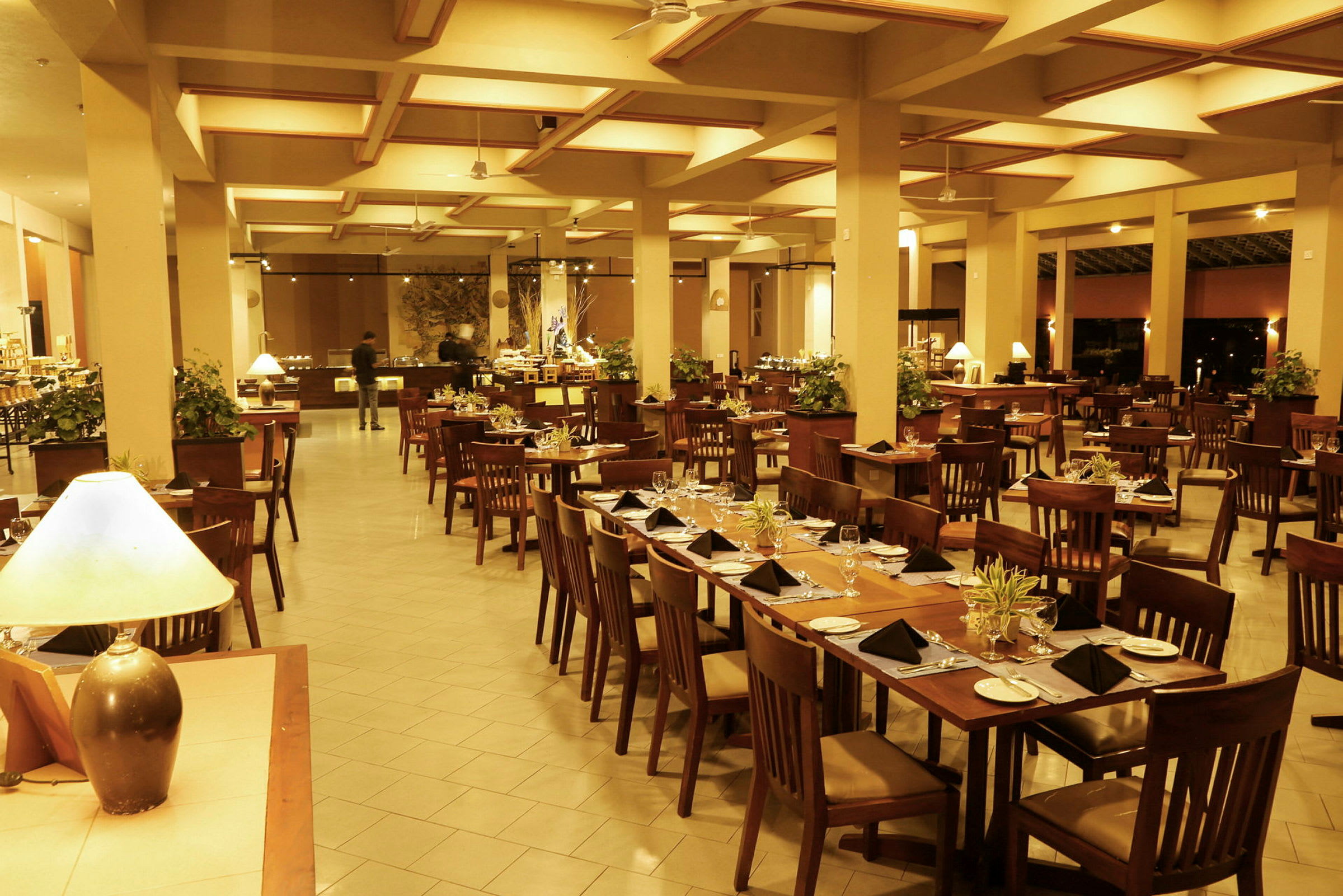 Suuri alue, jossa on ravintola, pöytiä ja tuoleja asiakkaille sekä buffet taustalla. (Tekoälyn luoma teksti)
