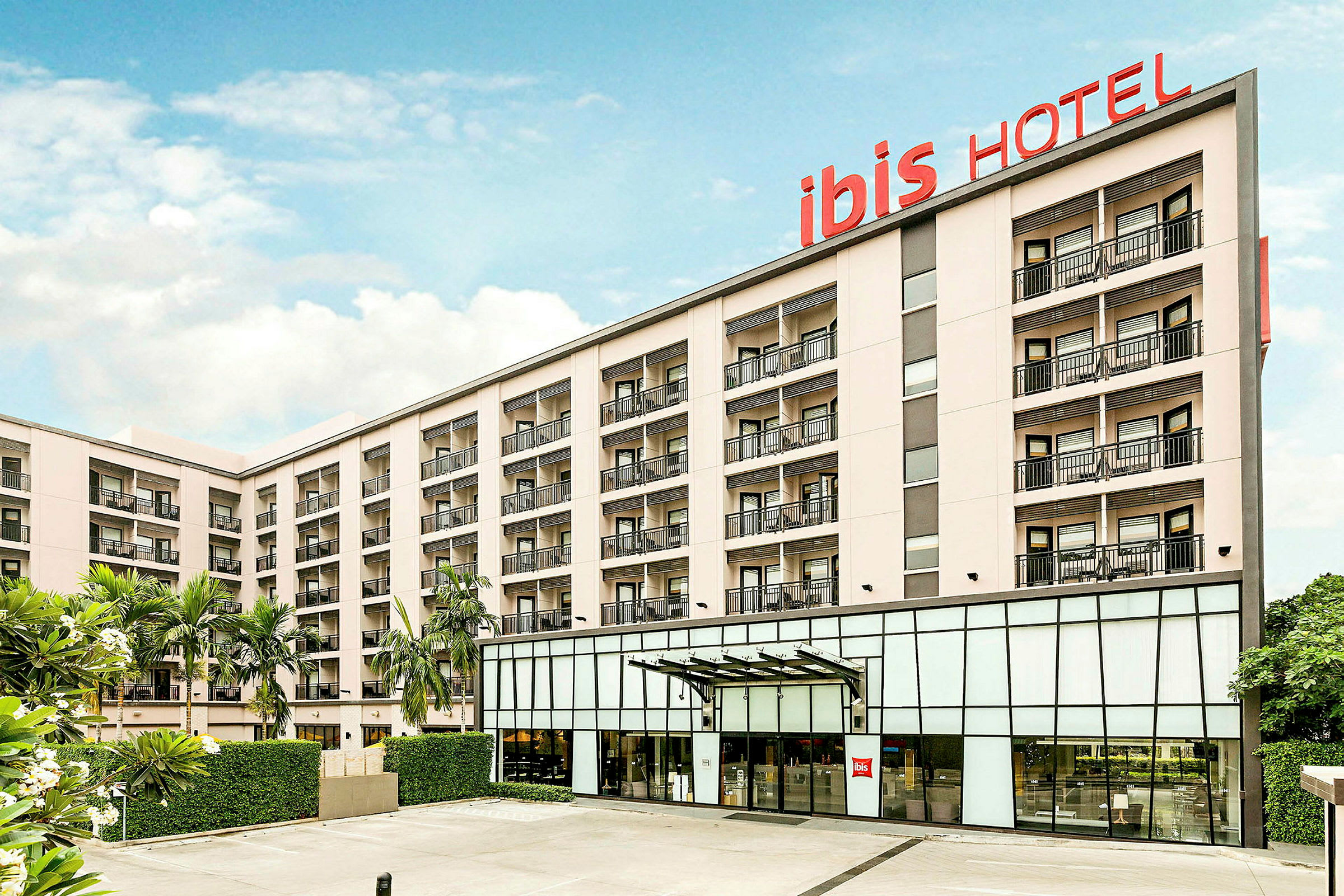 Useamman kerroksen hotellirakennus, jossa on parvekkeita ja kyltti 'ibis HOTEL'. (Tekoälyn luoma teksti)