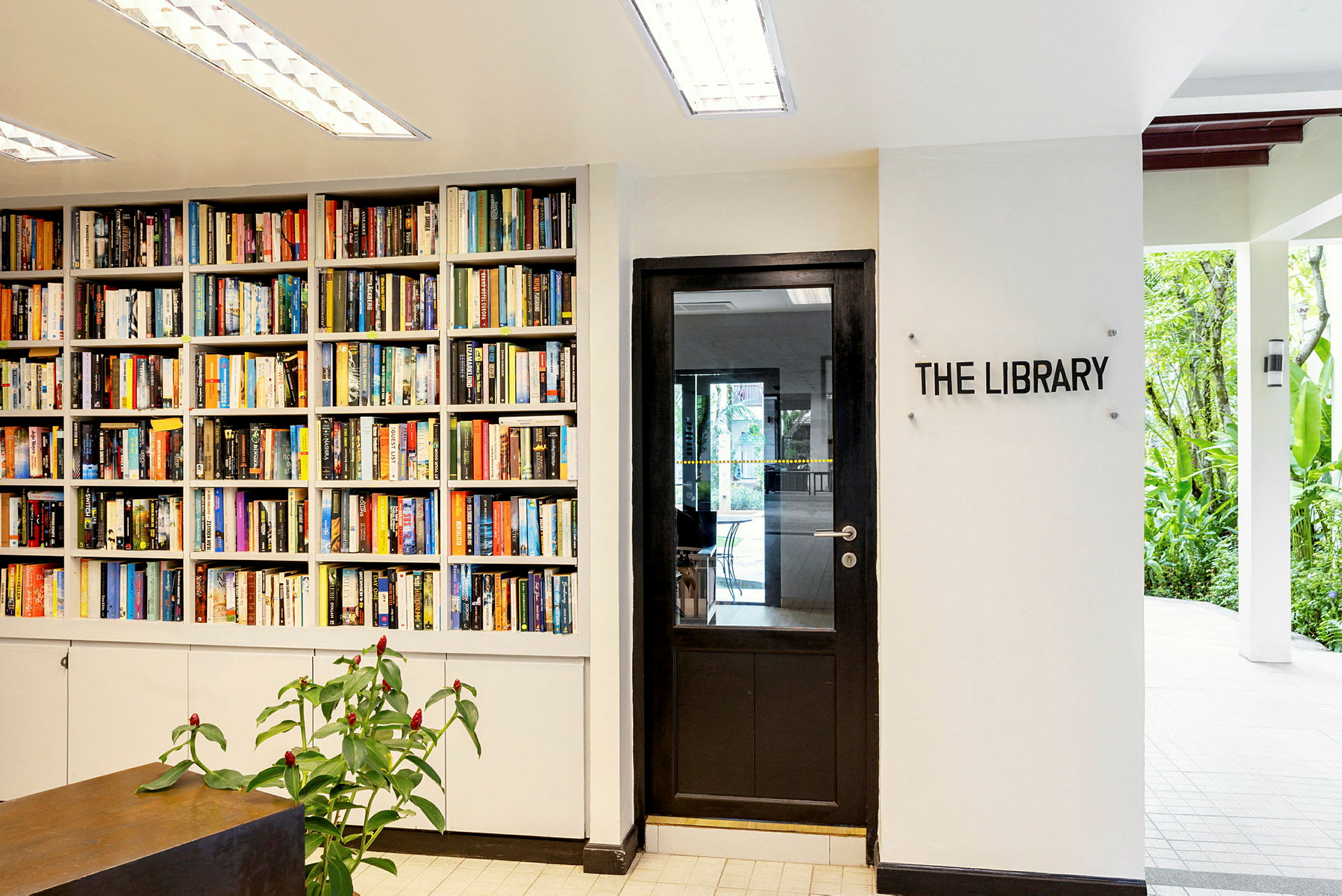 Kirjahylly täynnä kirjoja oven vieressä, jossa on merkki "The Library". (Tekoälyn luoma teksti)