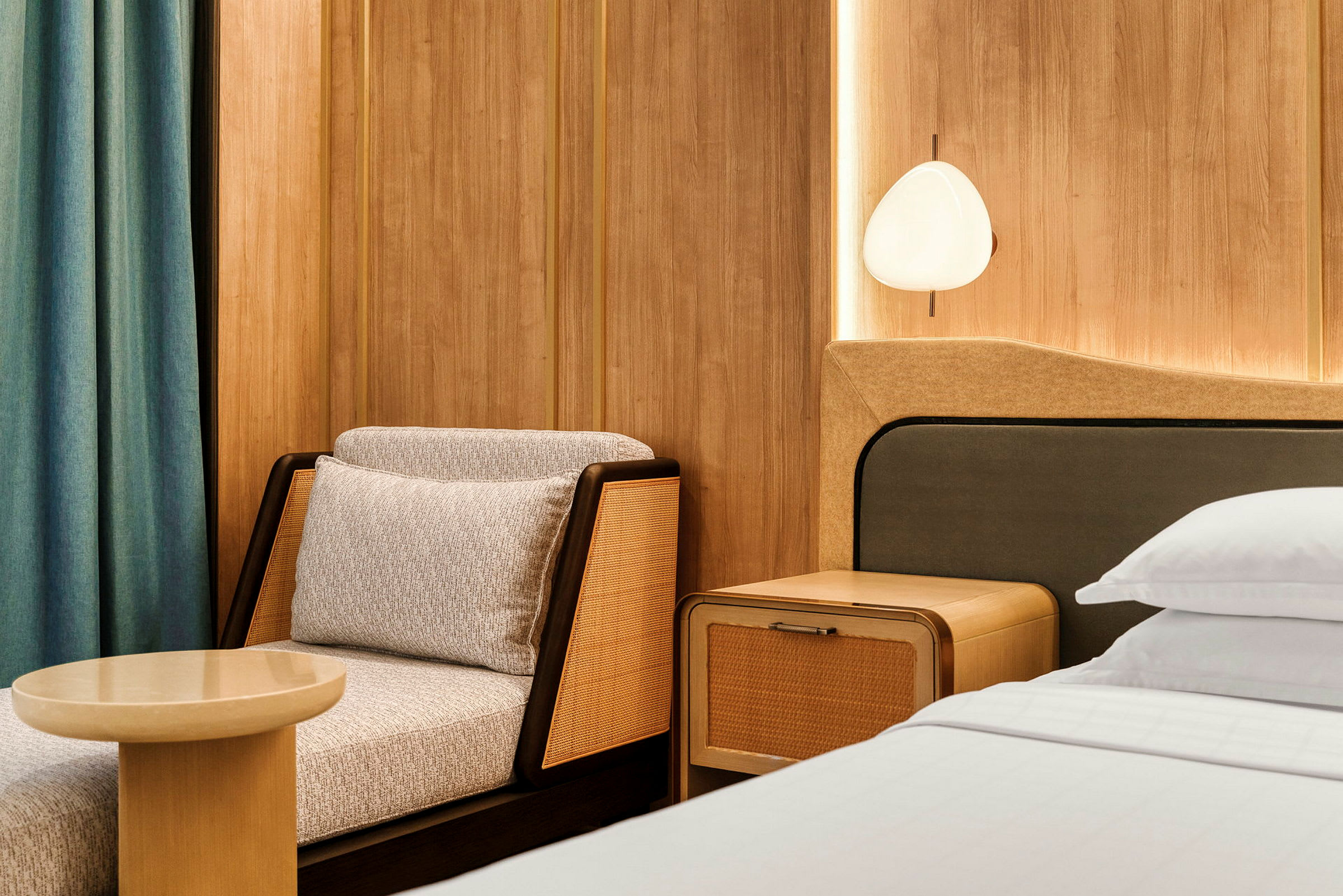 Istuma-alue ja osa sänkyä modernissa hotellihuoneessa, jossa on puupaneelit. (Tekoälyn luoma teksti)