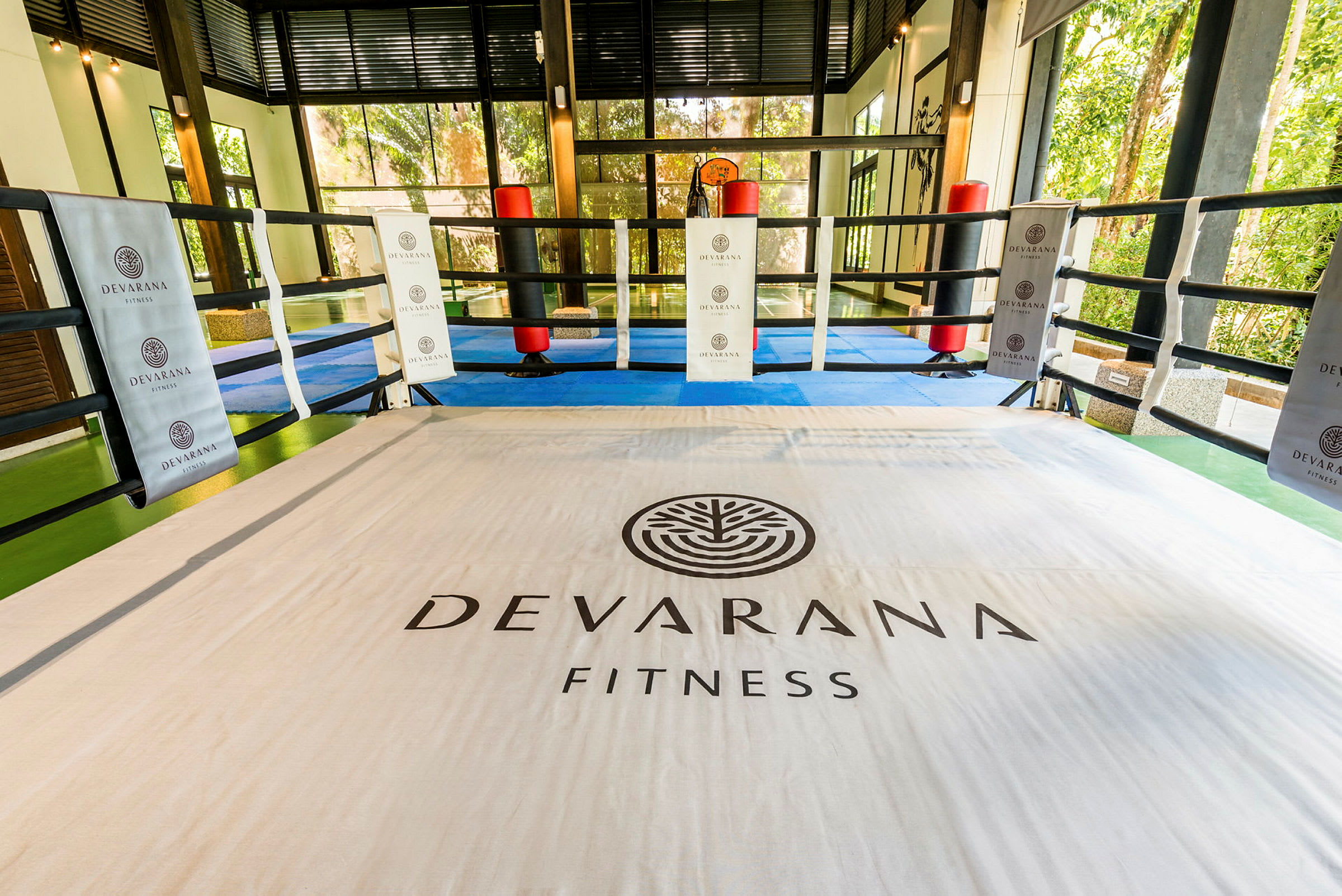 Sisätila harjoituskehä, johon on merkitty teksti "Devarana Fitness", ympärillä köydet. (Tekoälyn luoma teksti)