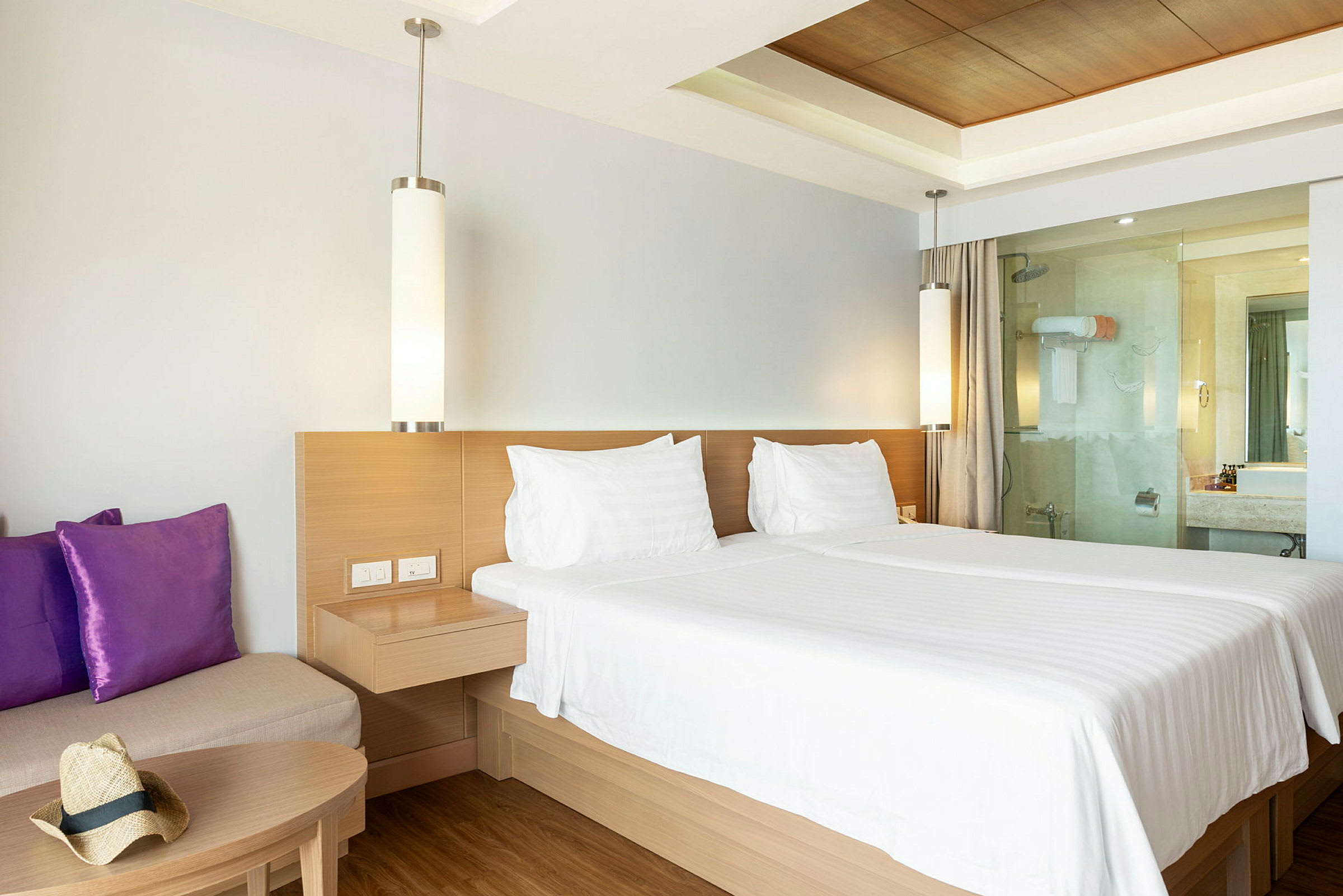 Hotellihuone, jossa on parivuode, sohva ja kylpyhuone. (Tekoälyn luoma teksti)