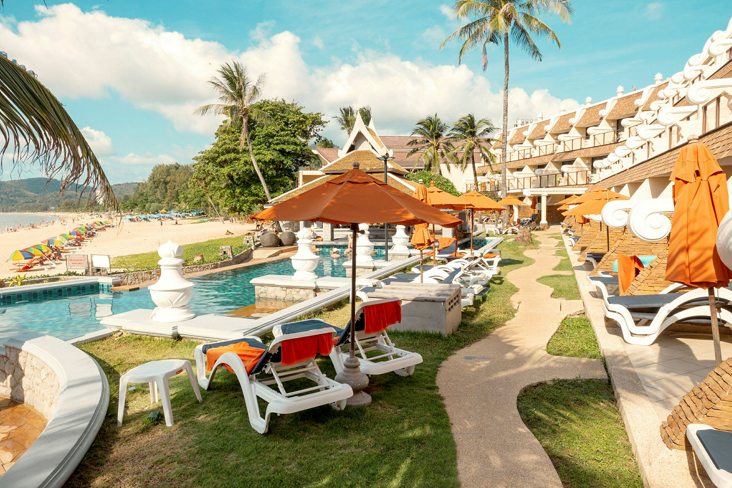 Uima-allasalue lähellä rantaa aurinkotuoleilla ja varjoilla. (Tekoälyn luoma teksti)