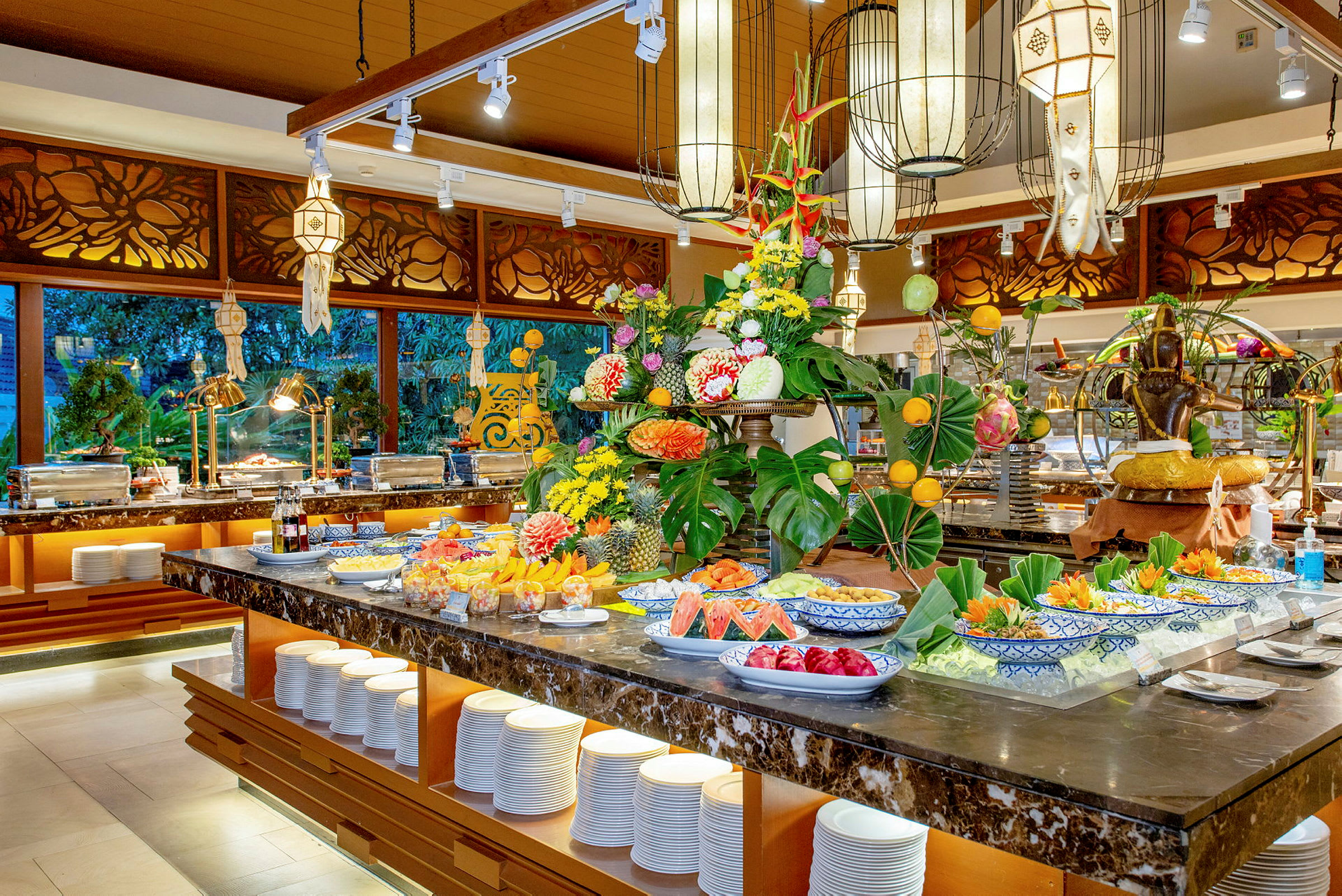 Buffet, jossa on tuoreita hedelmiä ja koristeellisia elementtejä ravintolassa. (Tekoälyn luoma teksti)
