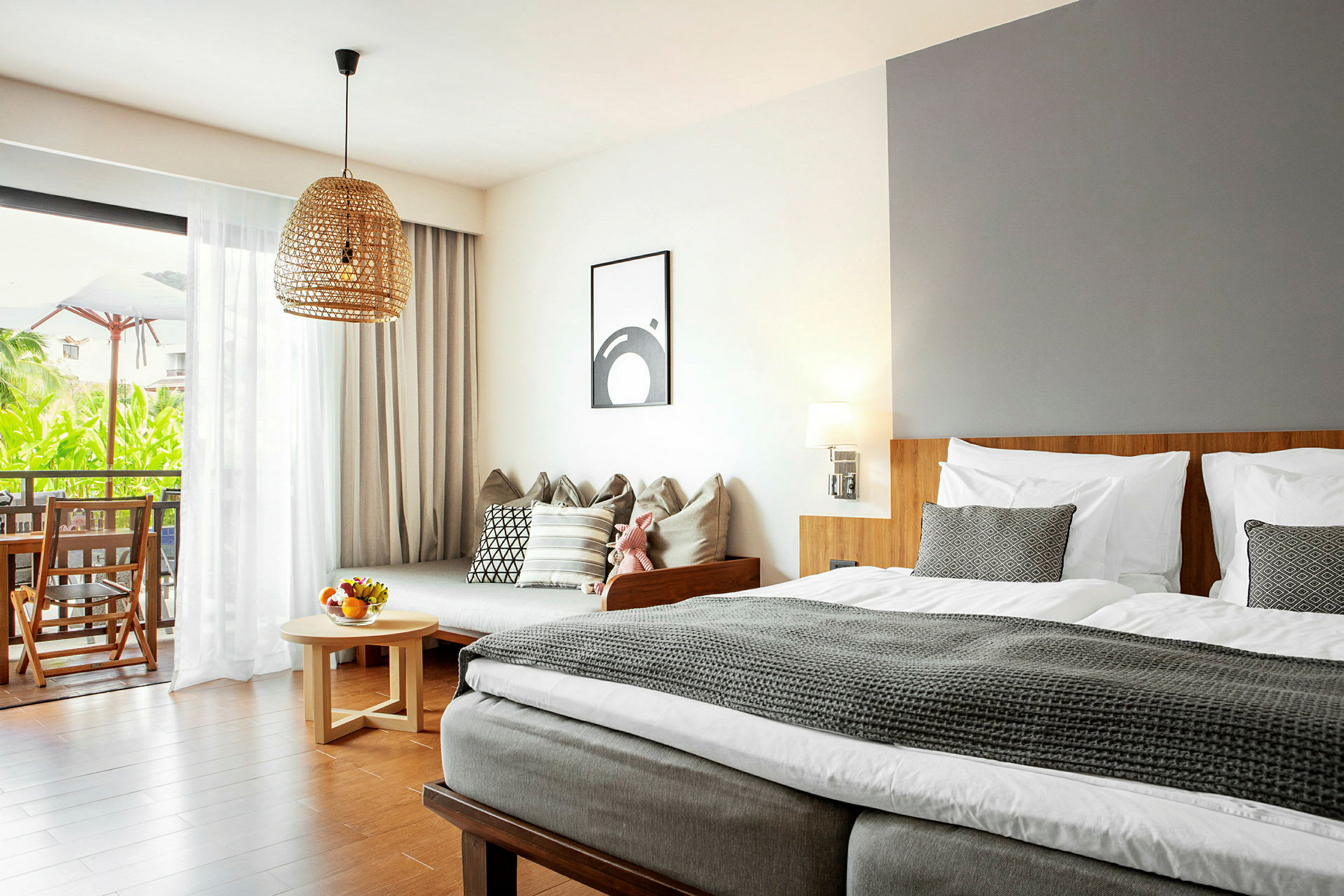 Modernisti sisustettu hotellihuone, jossa sänky, sohva ja parveke näkymällä. (Tekoälyn luoma teksti)